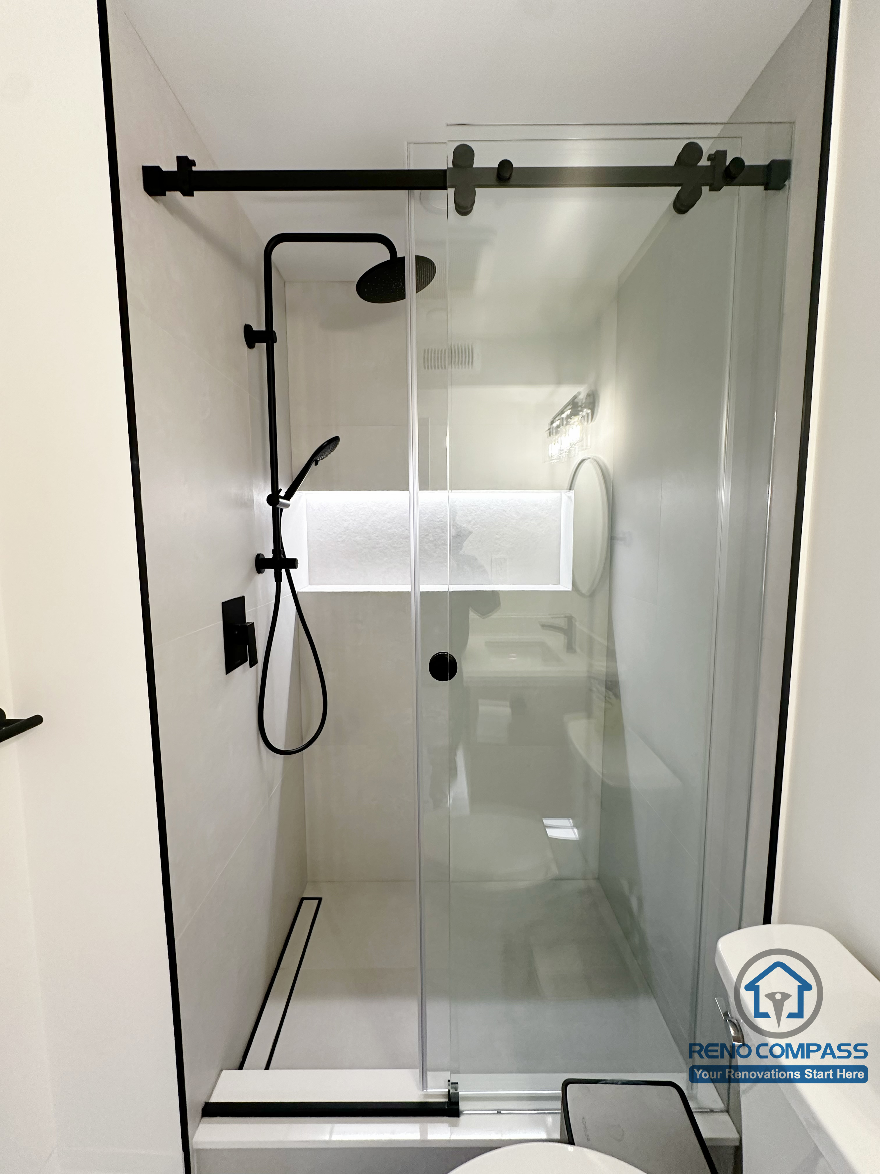 Basement bathroom shower renovation in Markham featuring a frameless glass enclosure, matte black shower fixtures, sliding door hardware, and a clean modern layout designed for durability and easy maintenance.