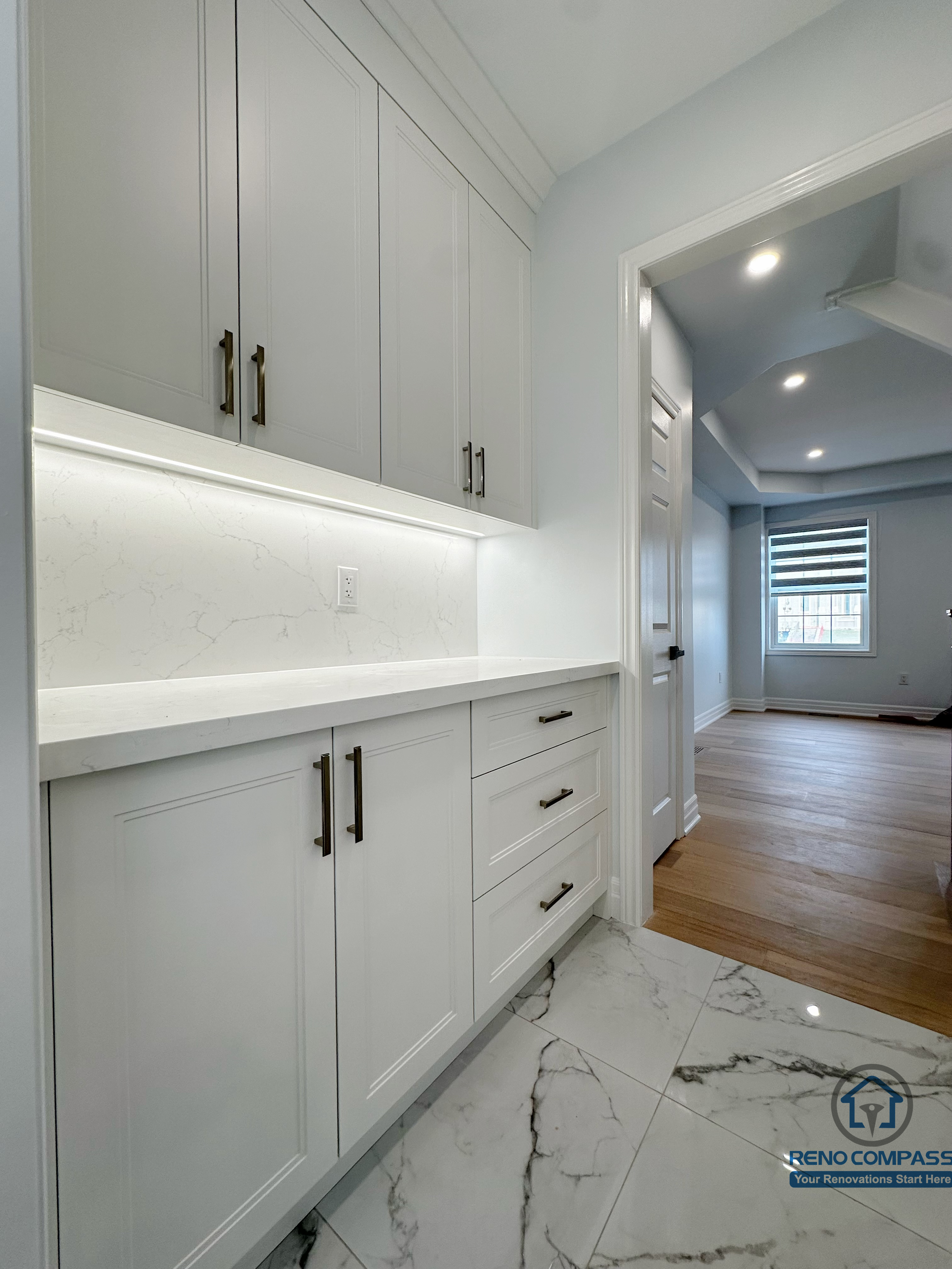 Open-concept main floor featuring a custom staircase with wood treads and black metal railing, seamlessly connecting the living area and upper level while enhancing natural light and spatial flow.