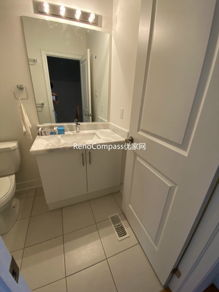 Stylish bathroom renovation in Richmond Hill featuring a sleek white vanity with marble countertop, large framed mirror, and contemporary LED lighting. RenoCompass designed this modern space for a bright, functional, and elegant everyday experience.