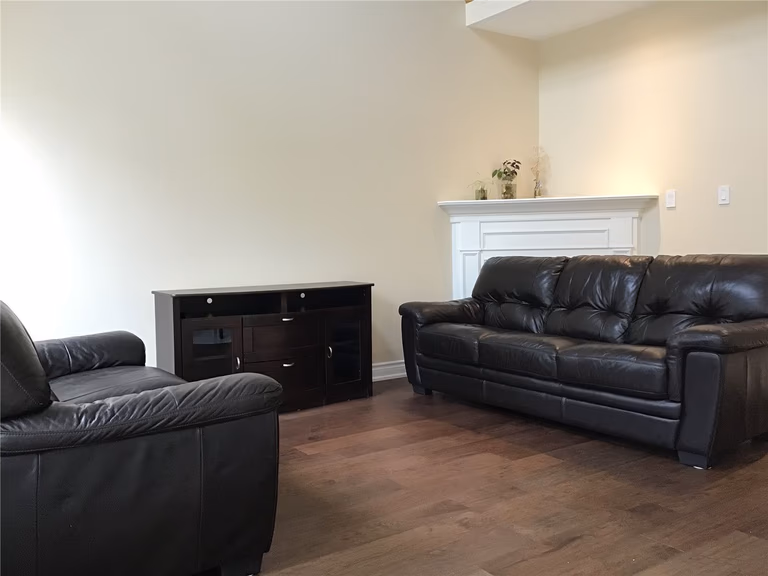 This Richmond Hill interior renovation includes a cozy and functional living room featuring warm-toned hardwood flooring, a clean fireplace mantle, and comfortable seating arrangements. The neutral wall palette enhances natural light while creating a calm and inviting atmosphere. Designed as part of a full home renovation by a professional Toronto renovation company, this space offers both everyday comfort and timeless appeal.