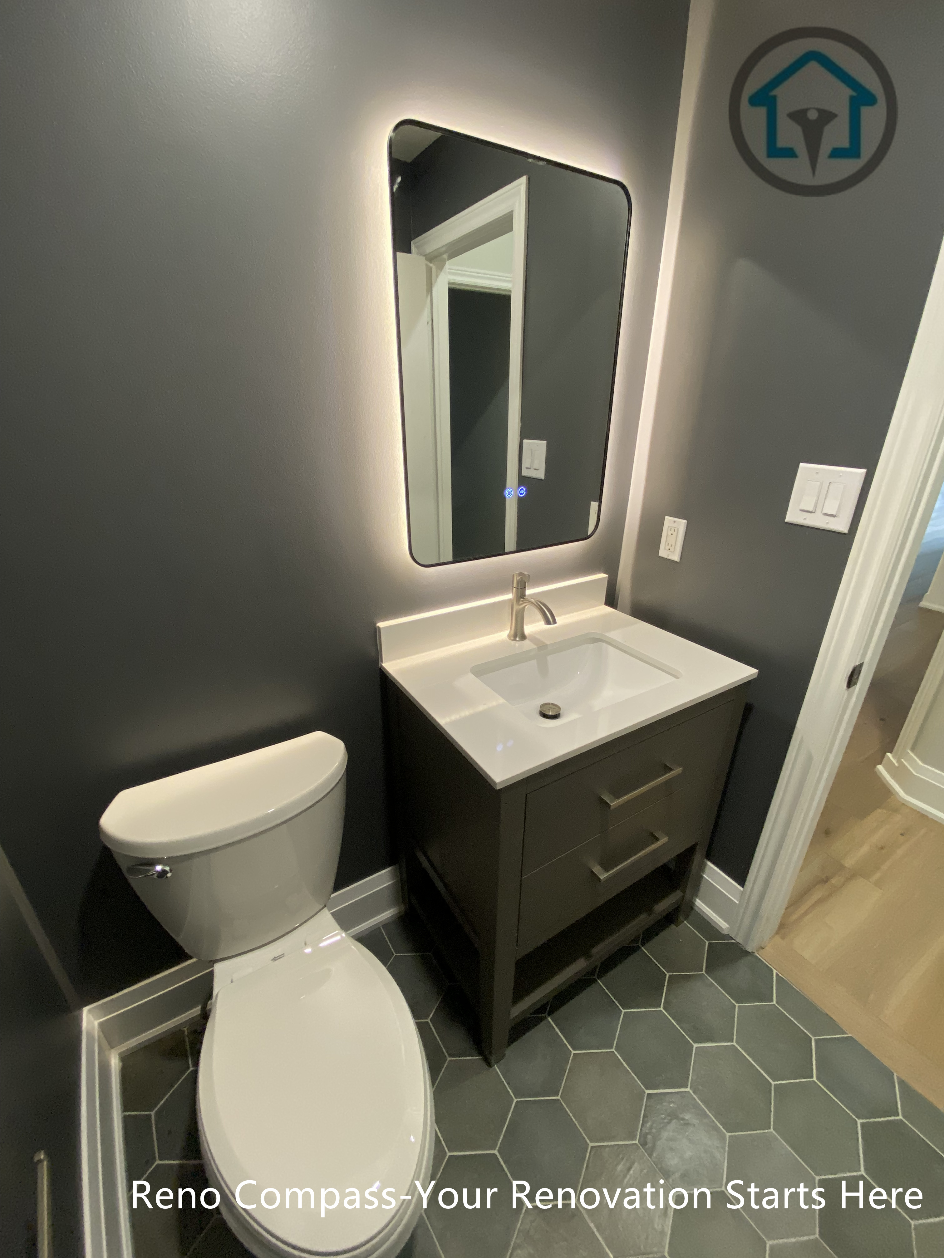 This Richmond Hill bathroom renovation features a modern powder room design with a compact vanity, backlit mirror, and dark wall finishes. The layout maximizes functionality in a small space while maintaining a clean, contemporary look, completed by a trusted Toronto renovation company.