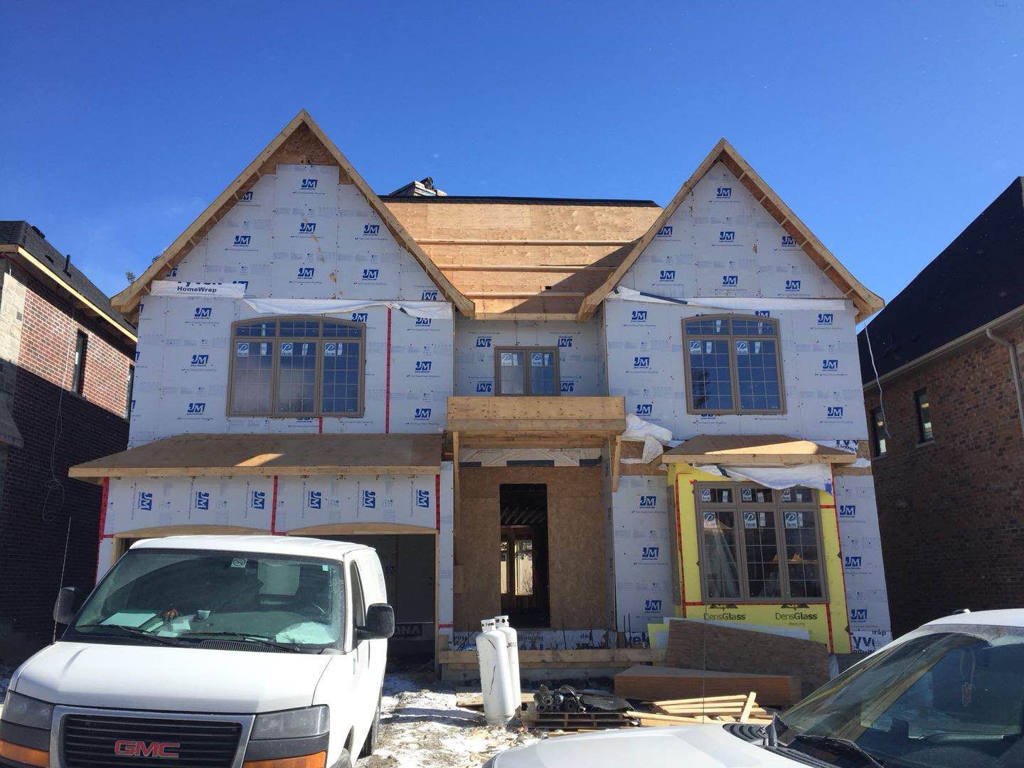 Construction phase of a Toronto custom home rebuild project, showing exterior structural work, window installation, and insulation preparation before the final façade installation. This stage is part of a professional Toronto design build process, demonstrating the structural craftsmanship and building expertise delivered by an experienced Toronto Renovation Company during a whole house renovation Toronto project.