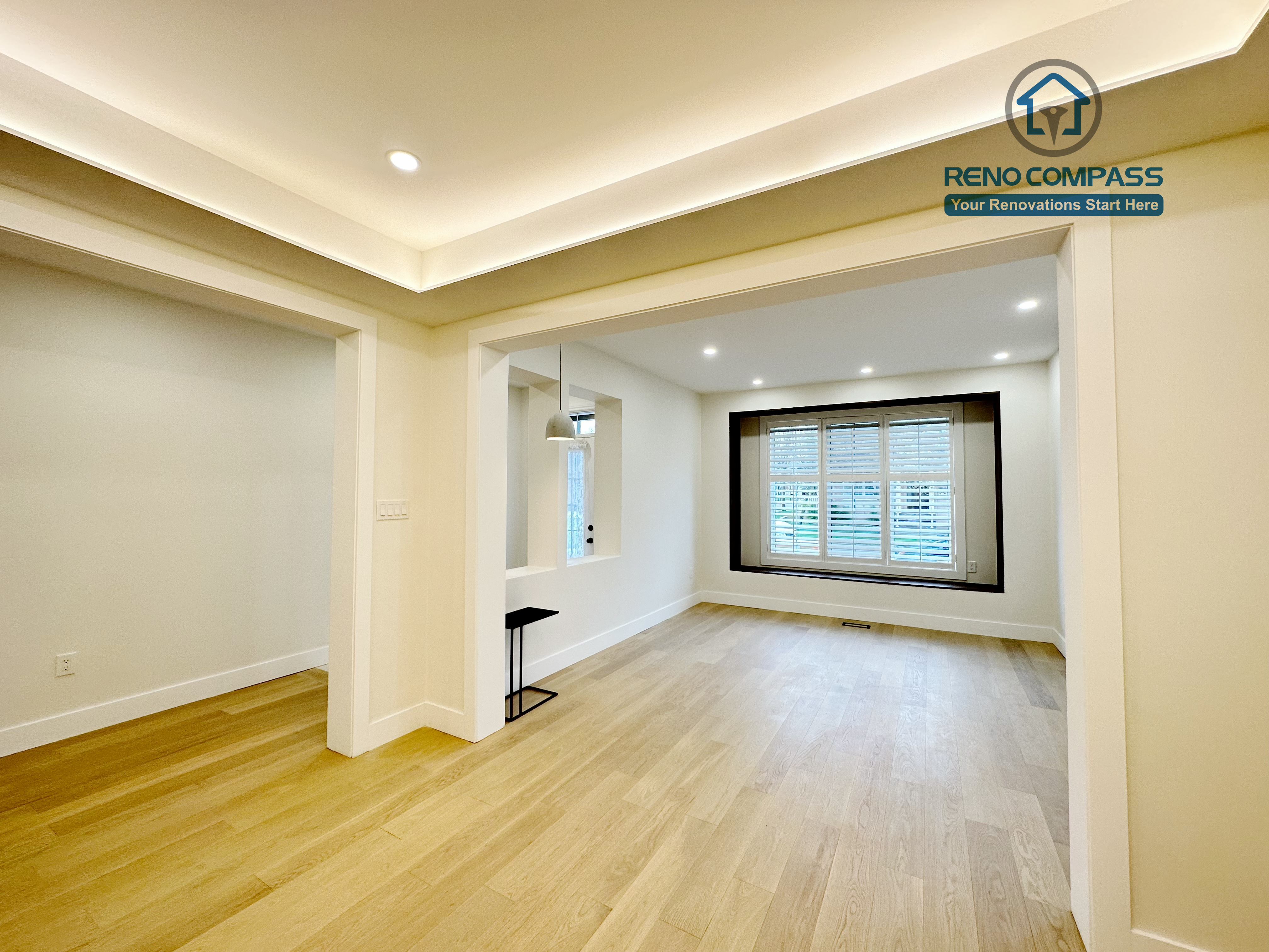 Bright interior room in a Richmond Hill home showcasing newly installed light-tone hardwood flooring, recessed ceiling lights, and custom window trim, enhancing natural light and a clean, modern finish.