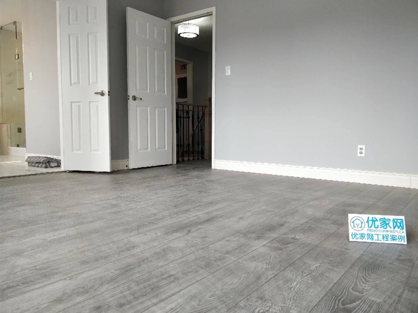 This renovated room in Ajax features modern grey wood flooring, fresh wall finishes, and enhanced natural lighting from the window. The clean and minimalist design creates a bright and comfortable living space, ideal for bedrooms or flexible use areas. As part of a full house renovation, the flooring upgrade improves durability while elevating the overall interior style.
