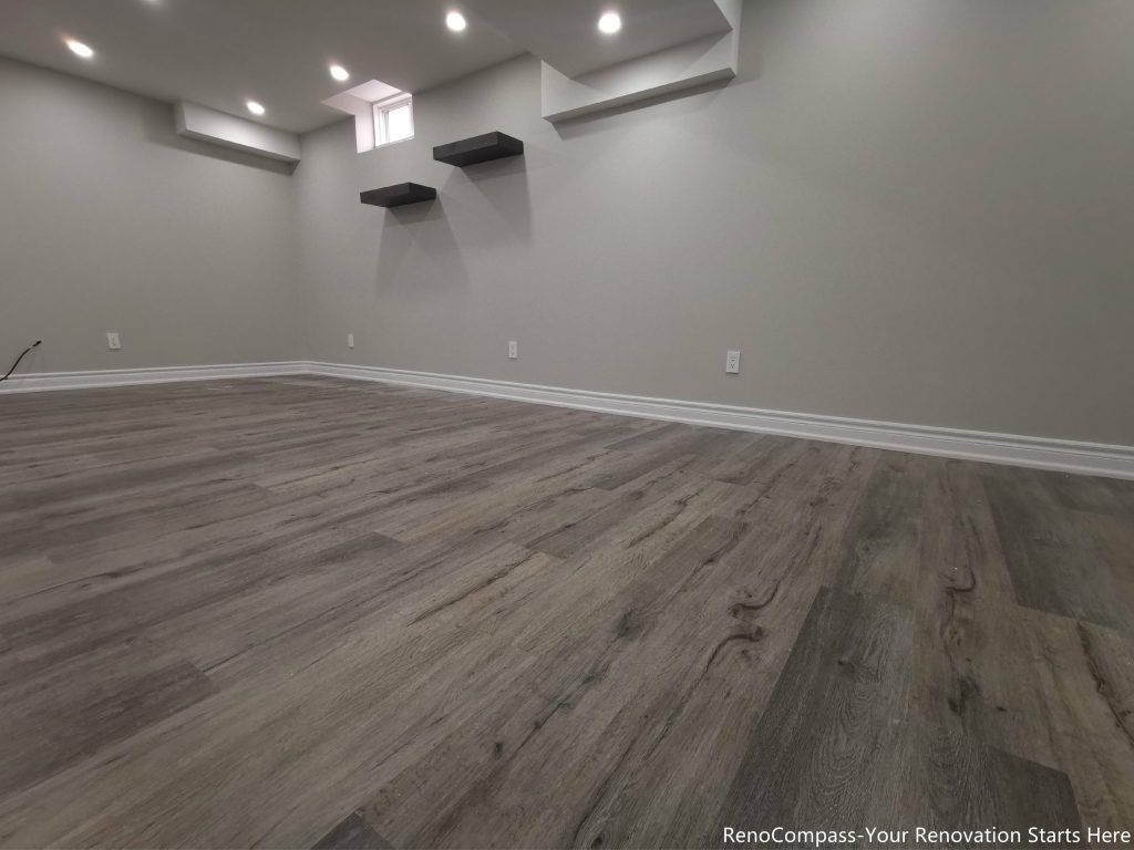 This Oakville basement renovation features a fully finished modern space with upgraded flooring, smooth ceilings, and recessed pot lights that create a bright and comfortable environment. The redesigned basement includes fresh wall finishes, clean trim work, and floating shelves for added functionality and storage. Completed by a professional Toronto renovation company, this basement upgrade enhances usable living space, improves lighting, and adds long-term value to the home while delivering a modern and versatile lower-level living area.