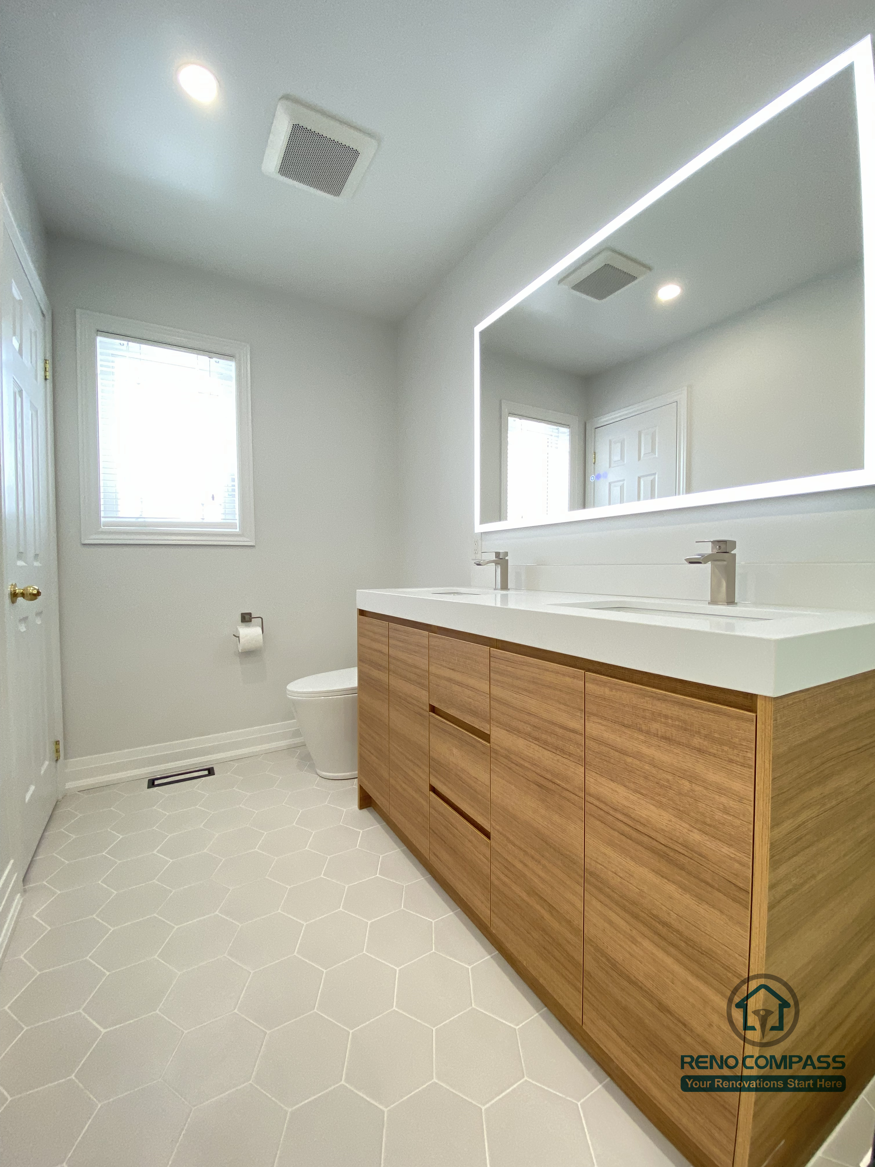 This image highlights a modern bathroom vanity renovation in Markham, featuring integrated drawers, a floating-style wood cabinet, and a sleek LED mirror. The design balances visual warmth with everyday practicality, completed by a trusted Toronto renovation company.