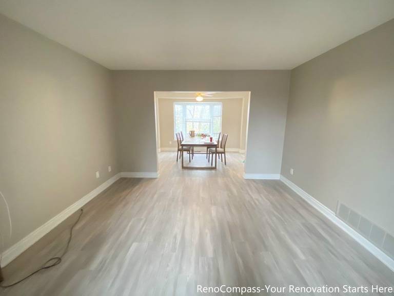 This Mississauga interior renovation showcases an open living and dining area finished with light-toned flooring and neutral wall colors. The extended sightline connects the living space seamlessly to the dining area, enhancing openness and natural light flow. Clean lines and a balanced layout improve daily functionality, creating a bright, versatile interior suitable for family living, entertaining, and long-term comfort.