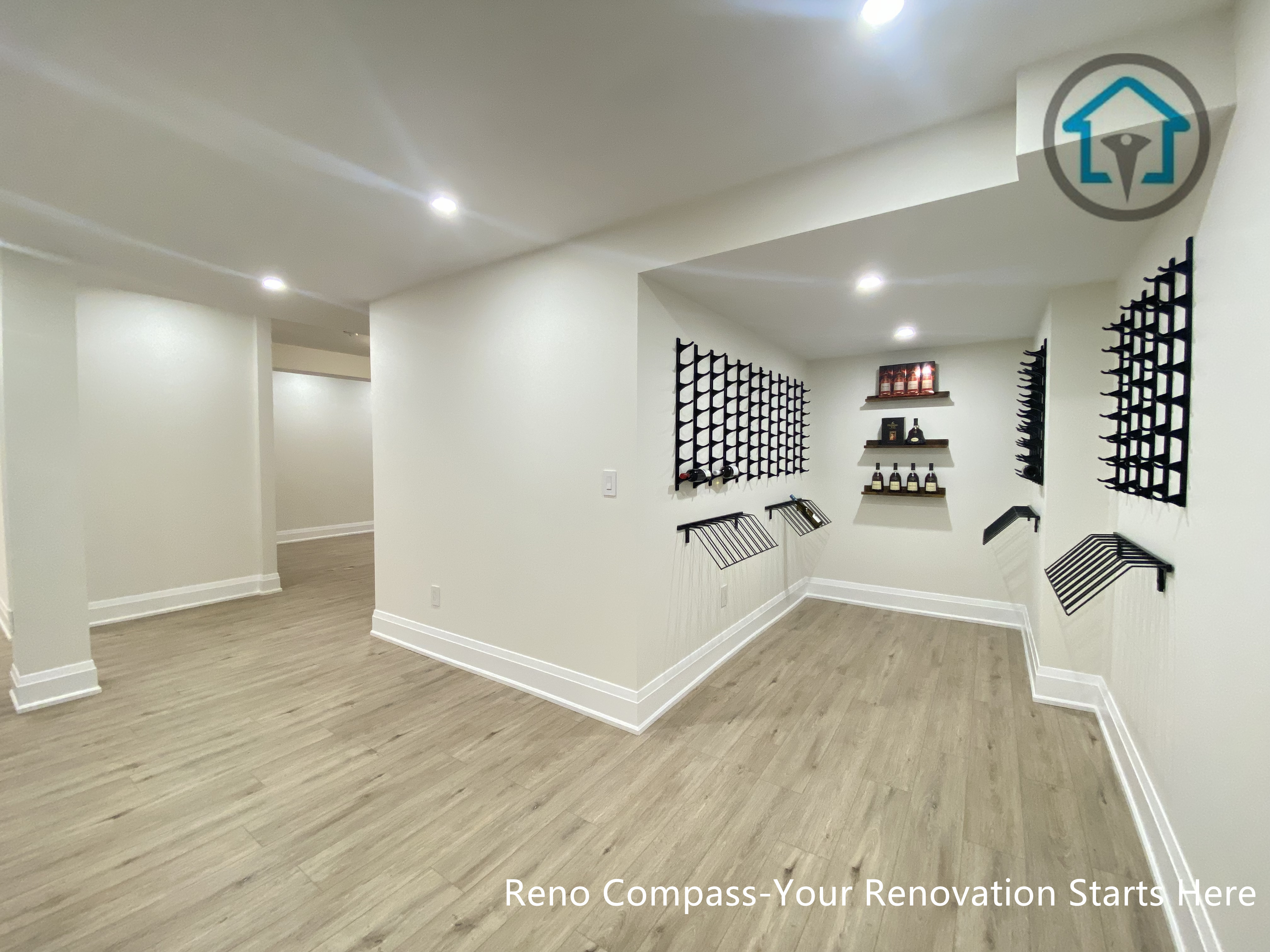 This image features a custom-designed wine cellar within a Richmond Hill interior renovation, showcasing symmetrical wall-mounted wine racks and a clean, gallery-style layout. The narrow corridor design maximizes bottle storage while maintaining visual order and ease of access. Neutral finishes and wood flooring add warmth and balance to the space. Designed and completed by Reno Compass, this wine storage solution reflects a refined approach to functional interior design for homes in Richmond Hill.