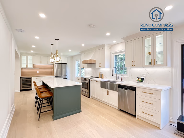 This Markham kitchen renovation features an open-concept layout centered around a custom green island with quartz countertops and seating. White cabinetry, brass hardware, and stainless steel appliances create a clean and cohesive design, while recessed lighting and wide-plank hardwood flooring enhance brightness and flow. Completed by a professional Toronto renovation company, Reno Compass Inc., the kitchen is designed for everyday functionality and long-term comfort.