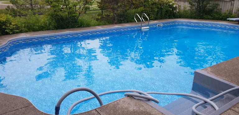 After renovation photo of a fully restored backyard swimming pool in Toronto. The new bright blue liner, clean water, and resurfaced edges highlight the professional pool transformation from old and damaged to modern and inviting. Expert pool renovation by local Toronto specialists.