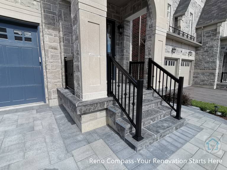 This Vaughan front entrance renovation highlights custom stone steps and a structured walkway leading to the main door. The natural stone finish, clean joint lines, and black metal railings create a refined and durable entry experience that seamlessly connects the driveway with the home’s front façade.
