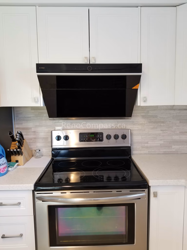 This Mississauga kitchen renovation features clean white cabinetry, modern backsplash tiles, and upgraded stainless steel appliances for a bright and functional cooking space. The sleek range hood and electric stove installation enhance both ventilation and efficiency while maintaining a contemporary aesthetic.

Completed by Reno Compass Inc., this kitchen upgrade combines modern design, practical layout improvements, and quality craftsmanship to create a stylish and comfortable everyday cooking environment.