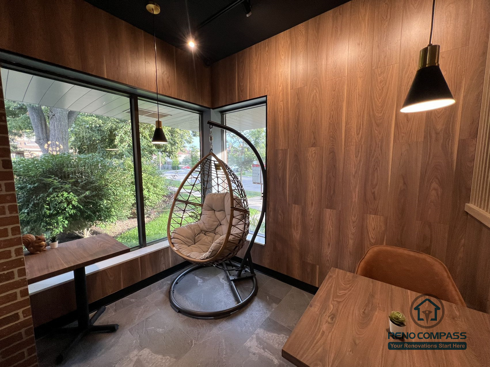 This Mississauga restaurant renovation features a cozy window-side seating and lounge area with warm wood wall finishes, pendant lighting, and natural daylight. The space creates a relaxed dining atmosphere that enhances customer comfort and overall restaurant experience.