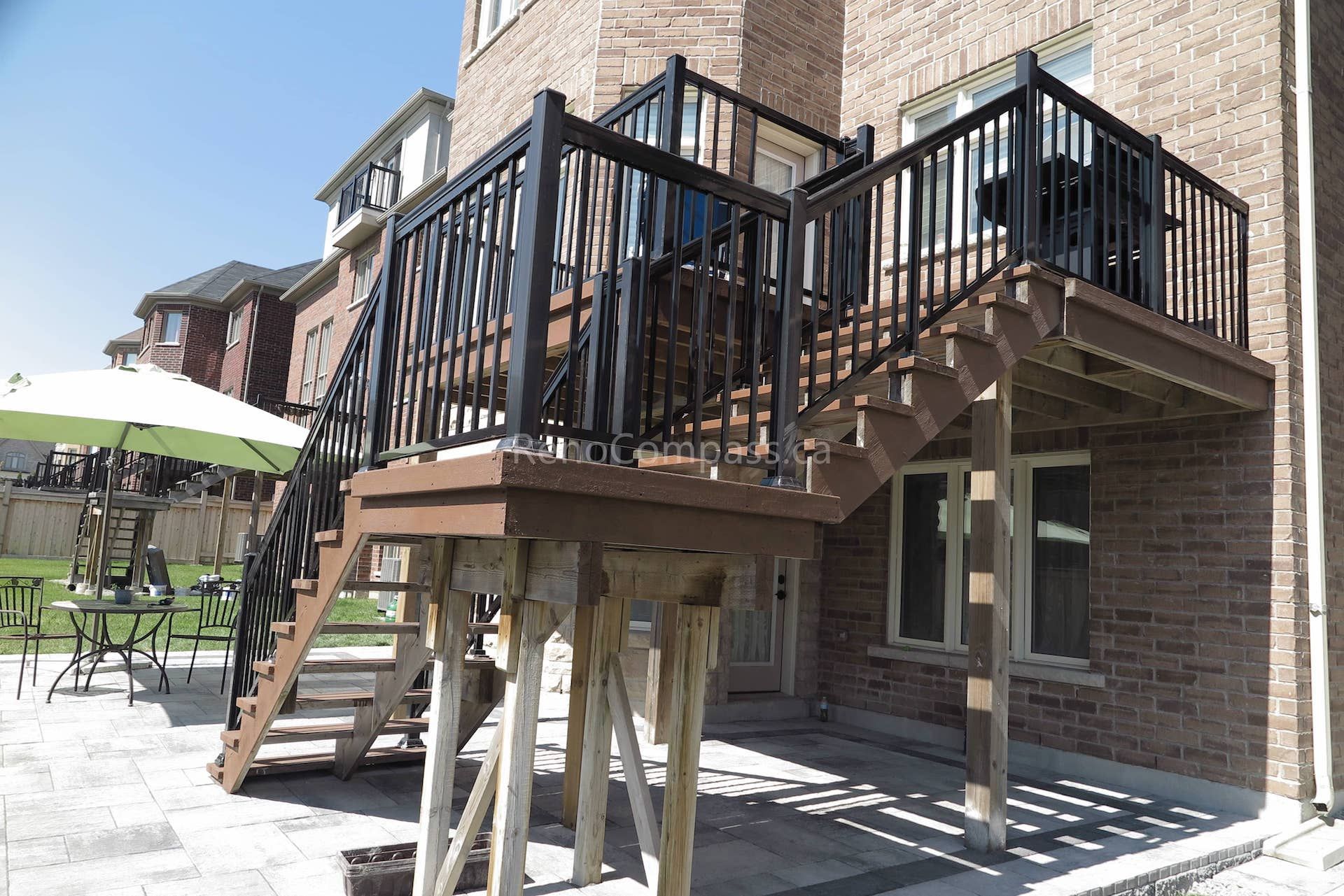 This Markham landscaping renovation showcases a custom-built elevated wooden deck with modern black aluminum railings and staircase, paired with a newly installed interlock stone patio below. The upgraded backyard design enhances outdoor living with a functional multi-level entertainment space, improved accessibility, and a clean contemporary look. Completed by Reno Compass, this project blends durable craftsmanship with stylish landscaping to create a comfortable and inviting backyard environment for homeowners.