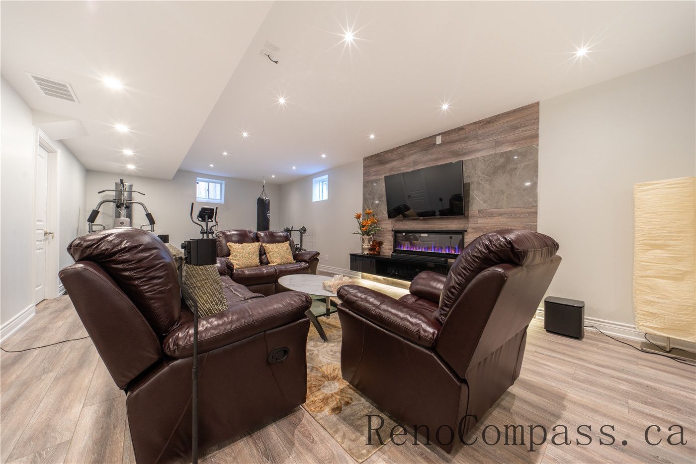 This Richmond Hill entire house interior renovation includes a fully finished basement featuring a modern entertainment and lounge area with a custom fireplace feature wall, recessed lighting, and durable flooring. The open layout provides a comfortable space for family gatherings, relaxation, and fitness activities. Professionally completed by a trusted Toronto renovation company, this basement renovation enhances usable living space while maintaining a stylish and functional design.
