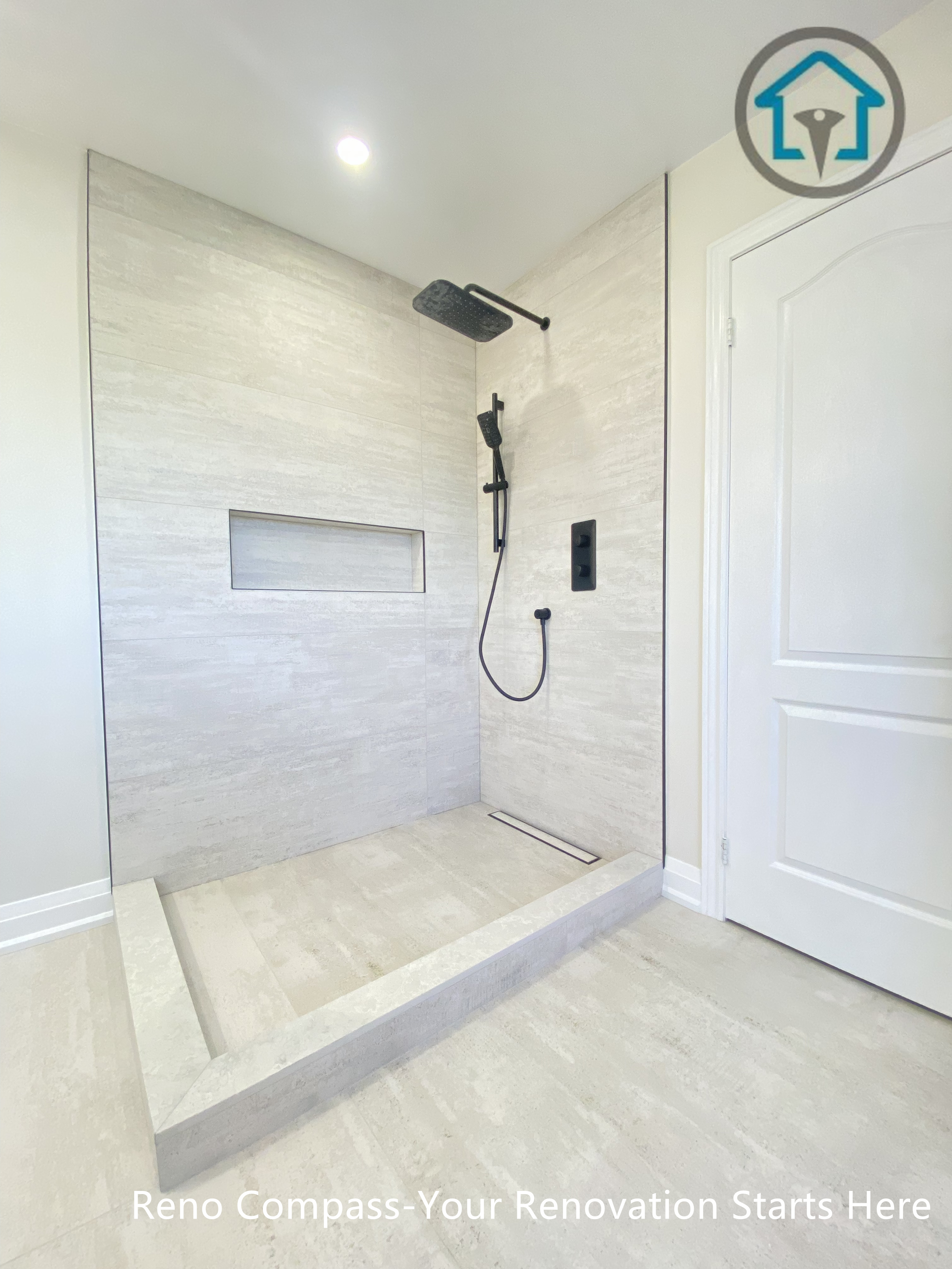 This Richmond Hill bathroom renovation highlights a minimalist walk-in shower with large-format tile walls, a recessed shower niche, and modern black fixtures. The clean lines and open layout enhance functionality and visual simplicity, completed by a professional Toronto renovation company.