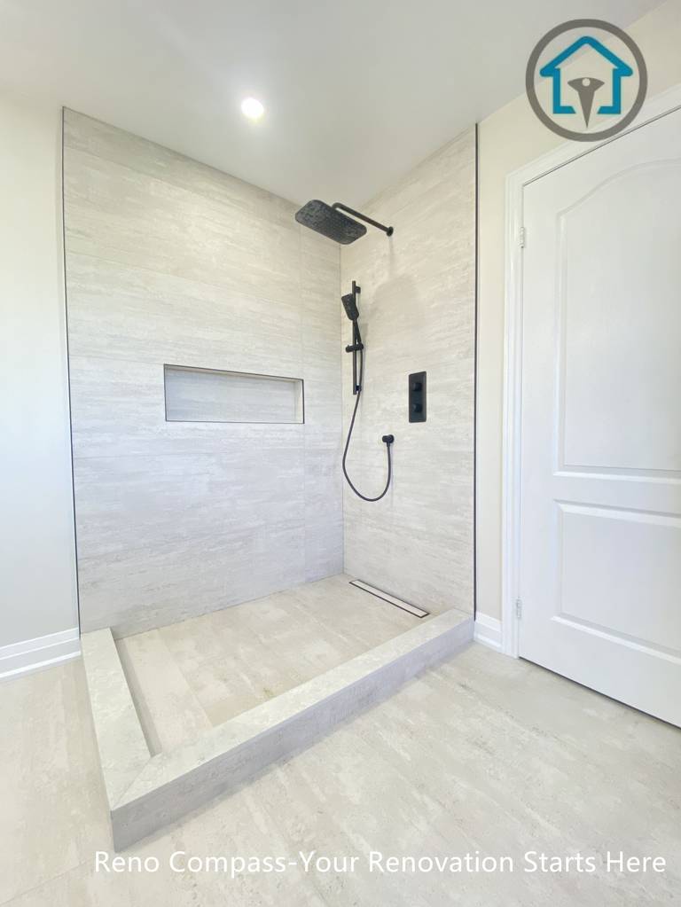 This Richmond Hill bathroom renovation highlights a minimalist walk-in shower with large-format tile walls, a recessed shower niche, and modern black fixtures. The clean lines and open layout enhance functionality and visual simplicity, completed by a professional Toronto renovation company.