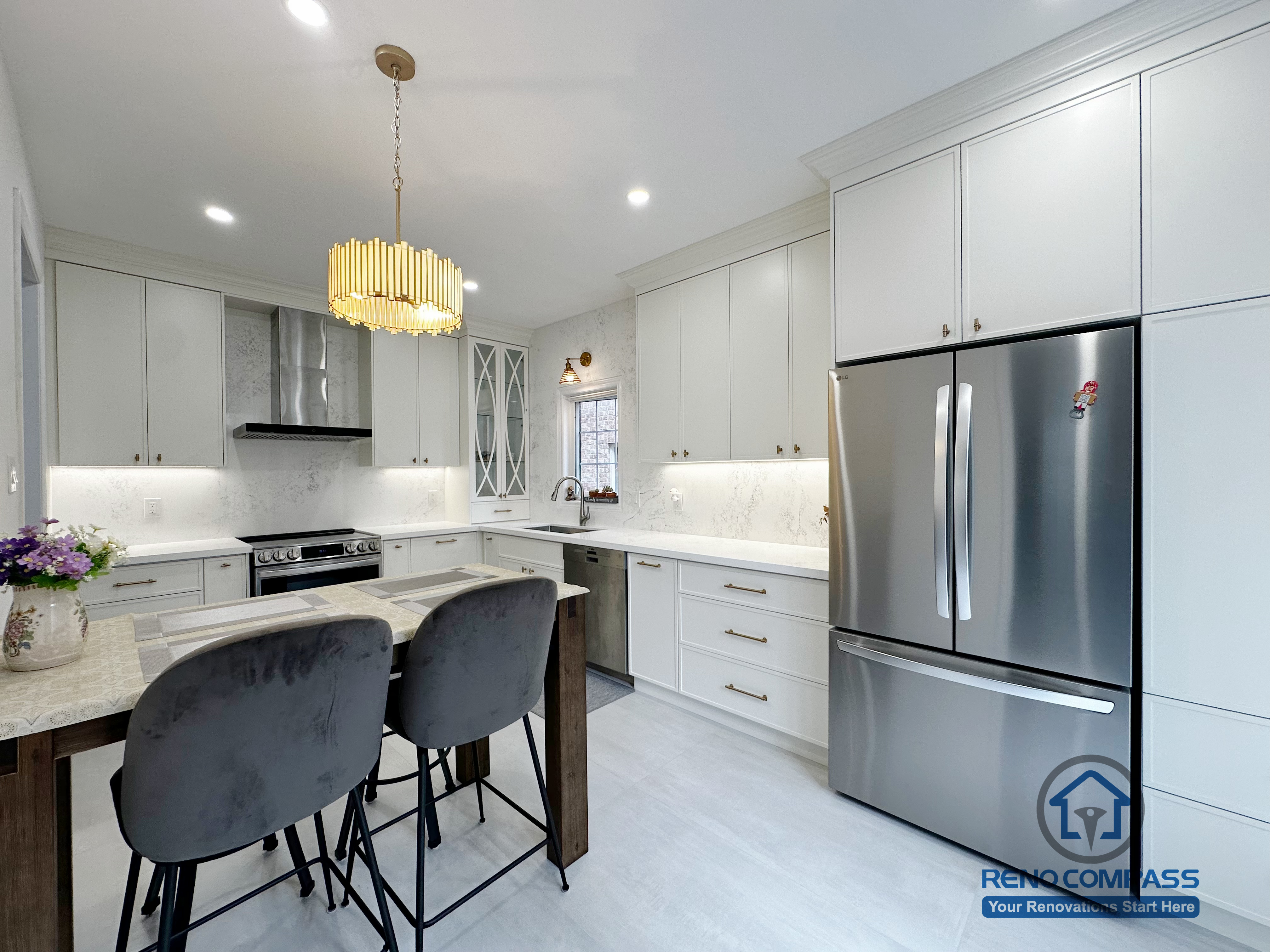 This Markham kitchen renovation features a clean, functional layout with custom white cabinetry, quartz countertops, and full-height integrated storage. The dining island provides comfortable seating while maintaining clear circulation throughout the space. Stainless steel appliances, soft under-cabinet lighting, and a neutral palette work together to create a bright, practical kitchen designed for everyday cooking and family use.