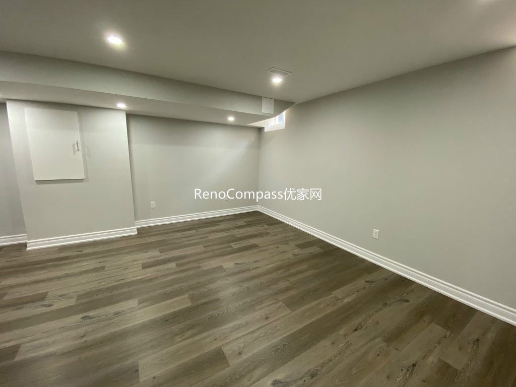 Spacious open-concept basement renovation in Richmond Hill featuring warm-toned laminate flooring, soft lighting, and sleek wall finishes. Reno Compass redesigned this area to maximize comfort and usability.