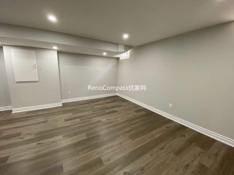 Spacious open-concept basement renovation in Richmond Hill featuring warm-toned laminate flooring, soft lighting, and sleek wall finishes. Reno Compass redesigned this area to maximize comfort and usability.