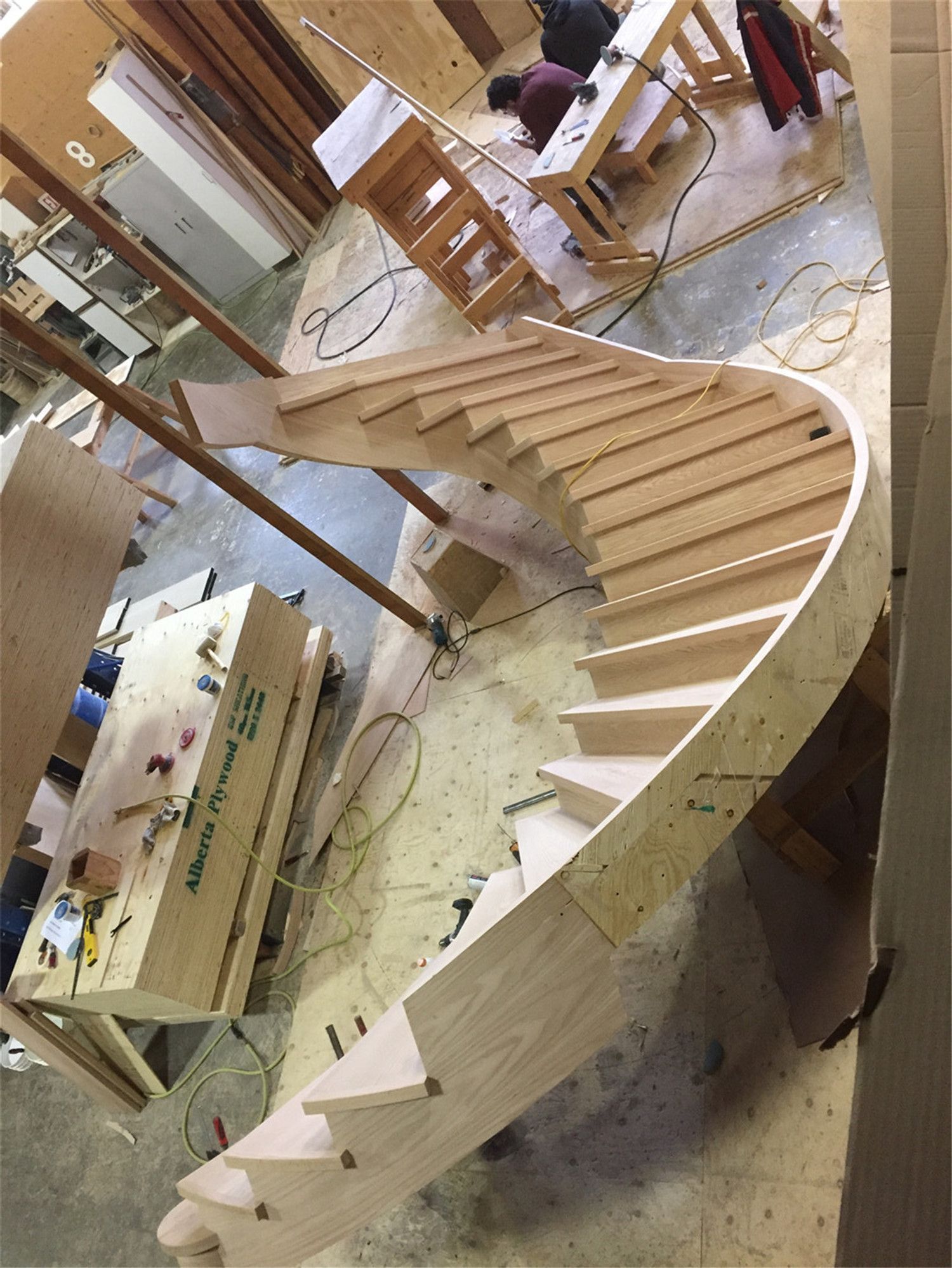 This image shows the fabrication stage of a custom curved hardwood staircase prepared for a Toronto stair renovation project. The precisely shaped stair structure demonstrates advanced woodworking techniques used to create smooth curves and evenly spaced treads. Each step is carefully measured and installed to ensure structural strength, safety, and visual harmony. As a trusted Toronto Renovation Company, Reno Compass Inc. delivers high-quality custom staircase solutions, combining skilled craftsmanship with durable materials for residential projects across Toronto and the Greater Toronto Area.