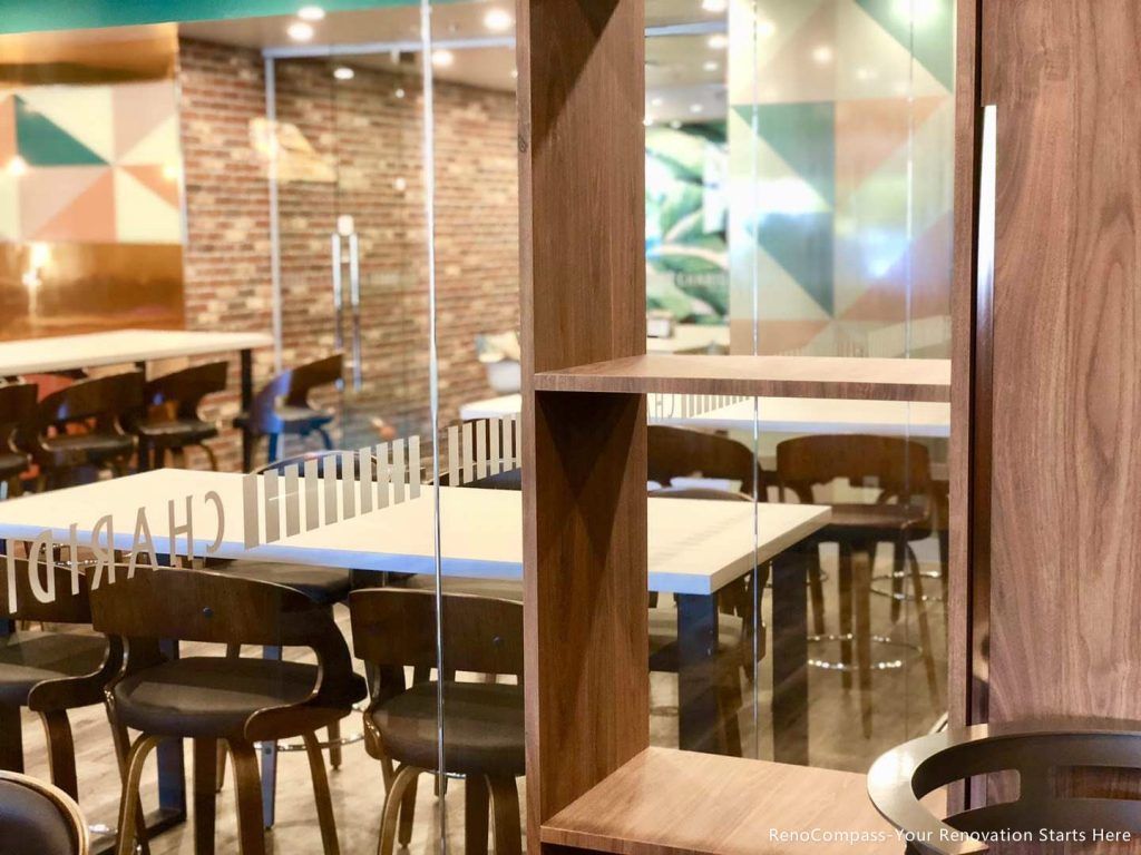 This Barrie commercial renovation features a stylish dining and meeting area with custom furniture, wood-look flooring, and decorative feature walls combining brick and tropical design elements. The inviting layout enhances customer comfort and social interaction within the bubble tea shop. Completed by Reno Compass Inc., a professional Toronto renovation company, this project reflects modern commercial interior design tailored for cafés, dessert shops, and retail spaces across Barrie and the GTA.