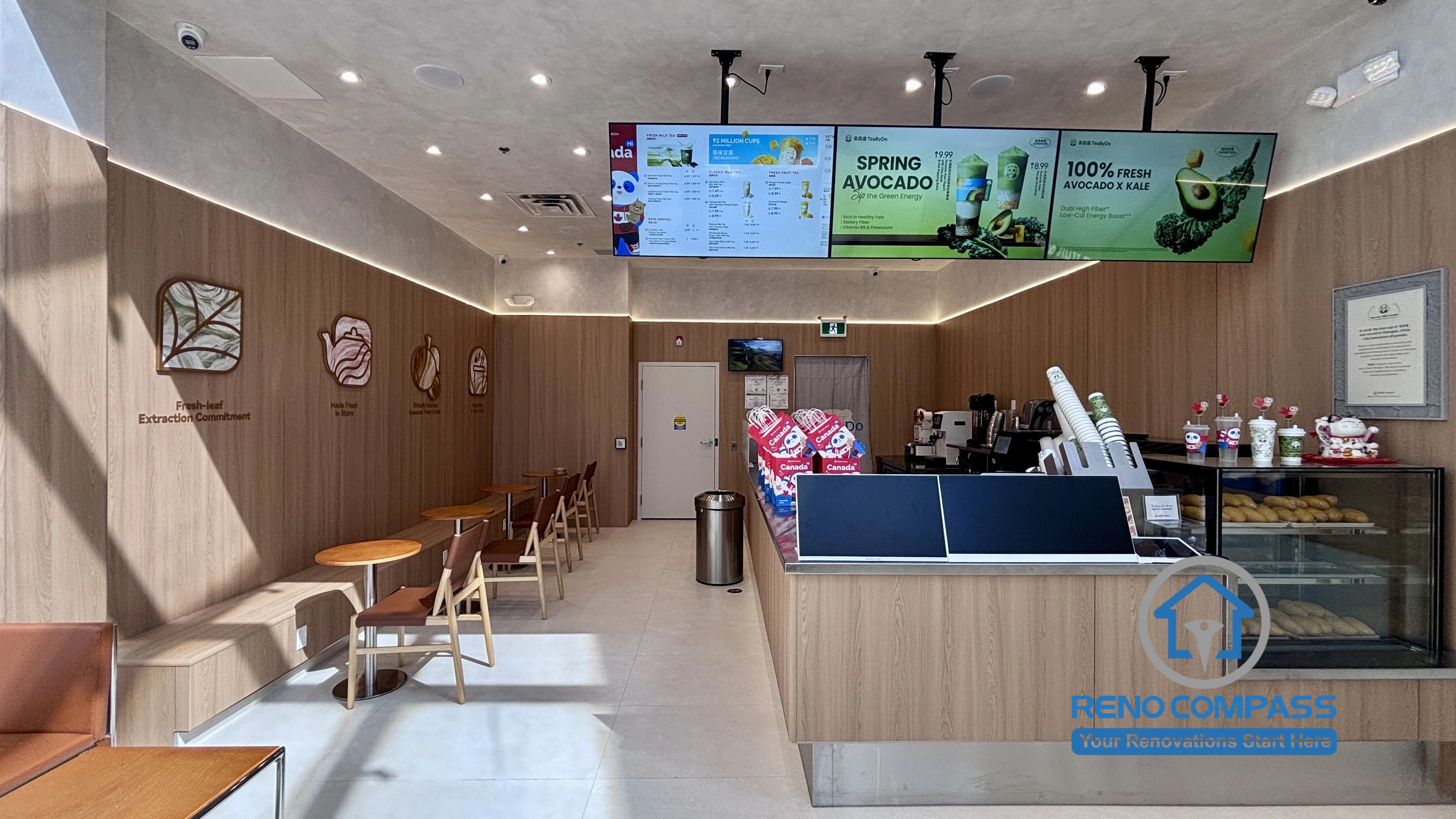 Completed TEABYDO bubble tea shop renovation in Richmond Hill featuring a modern beverage service counter, custom wood-tone commercial millwork, customer seating area, digital menu boards, integrated LED lighting, and clean minimalist café interior design. This commercial renovation project was completed by Reno Compass serving Richmond Hill, Toronto, and the GTA.