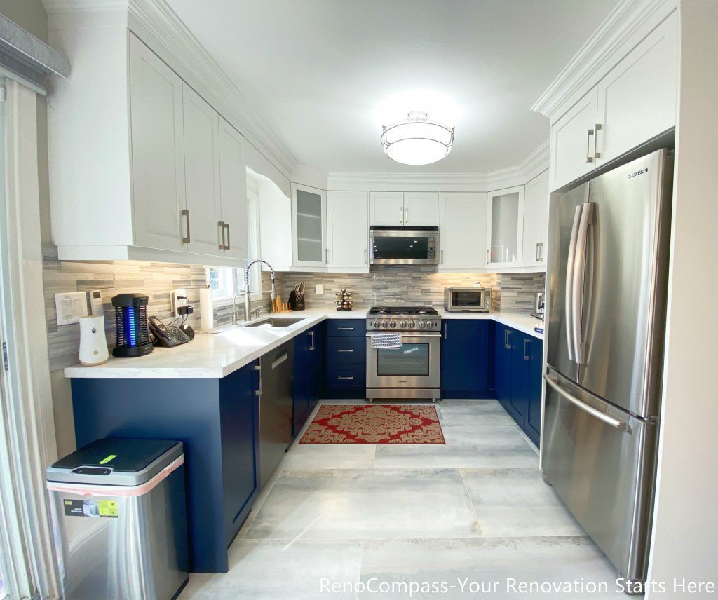 A modern U-shaped kitchen completed as part of a Newmarket interior renovation, featuring two-tone cabinetry, quartz countertops, stainless steel appliances, and a functional layout designed for daily use by a Toronto renovation company.