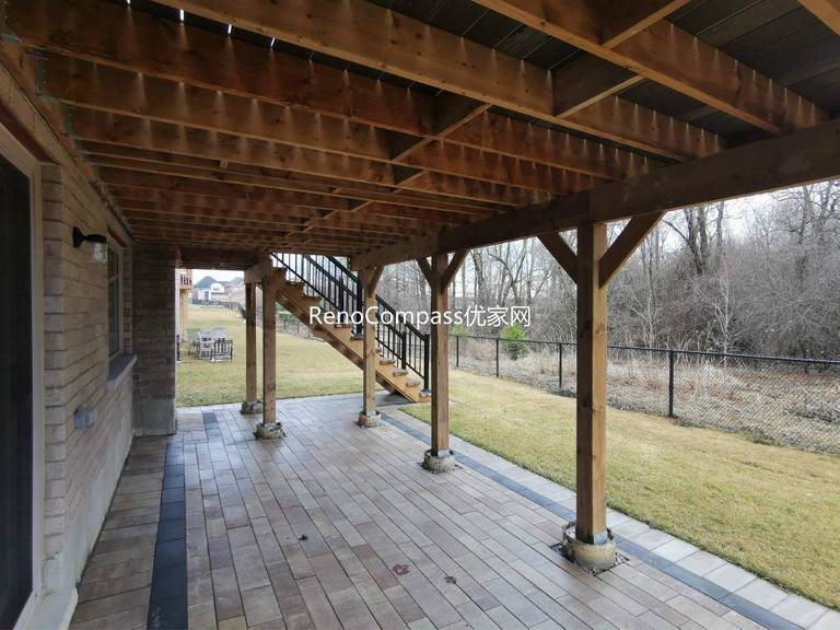 Custom elevated deck renovation in Aurora featuring composite decking, modern glass and aluminum railings, and a covered patio structure below. This professionally built outdoor space provides added functionality, weather protection, and a stylish backyard upgrade that enhances both usability and property value.