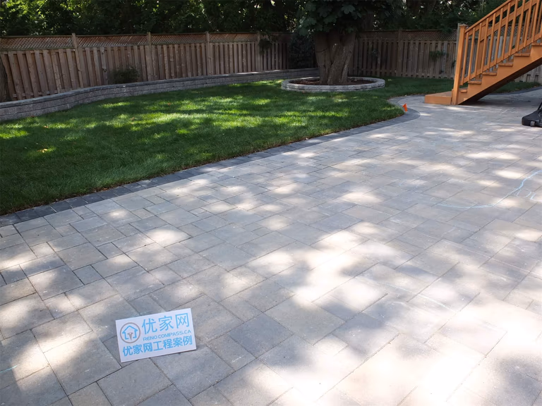 This North York landscaping renovation features a spacious backyard interlocking patio designed for durability and everyday outdoor use. Large-format pavers were installed with precise alignment to create a clean, level surface suitable for seating, circulation, and connection to the raised deck. The patio layout integrates seamlessly with the surrounding lawn, retaining walls, and mature trees, ensuring proper drainage, structural stability, and long-term performance. This project demonstrates a balanced hardscape solution that enhances backyard functionality while maintaining a refined residential landscape in North York.