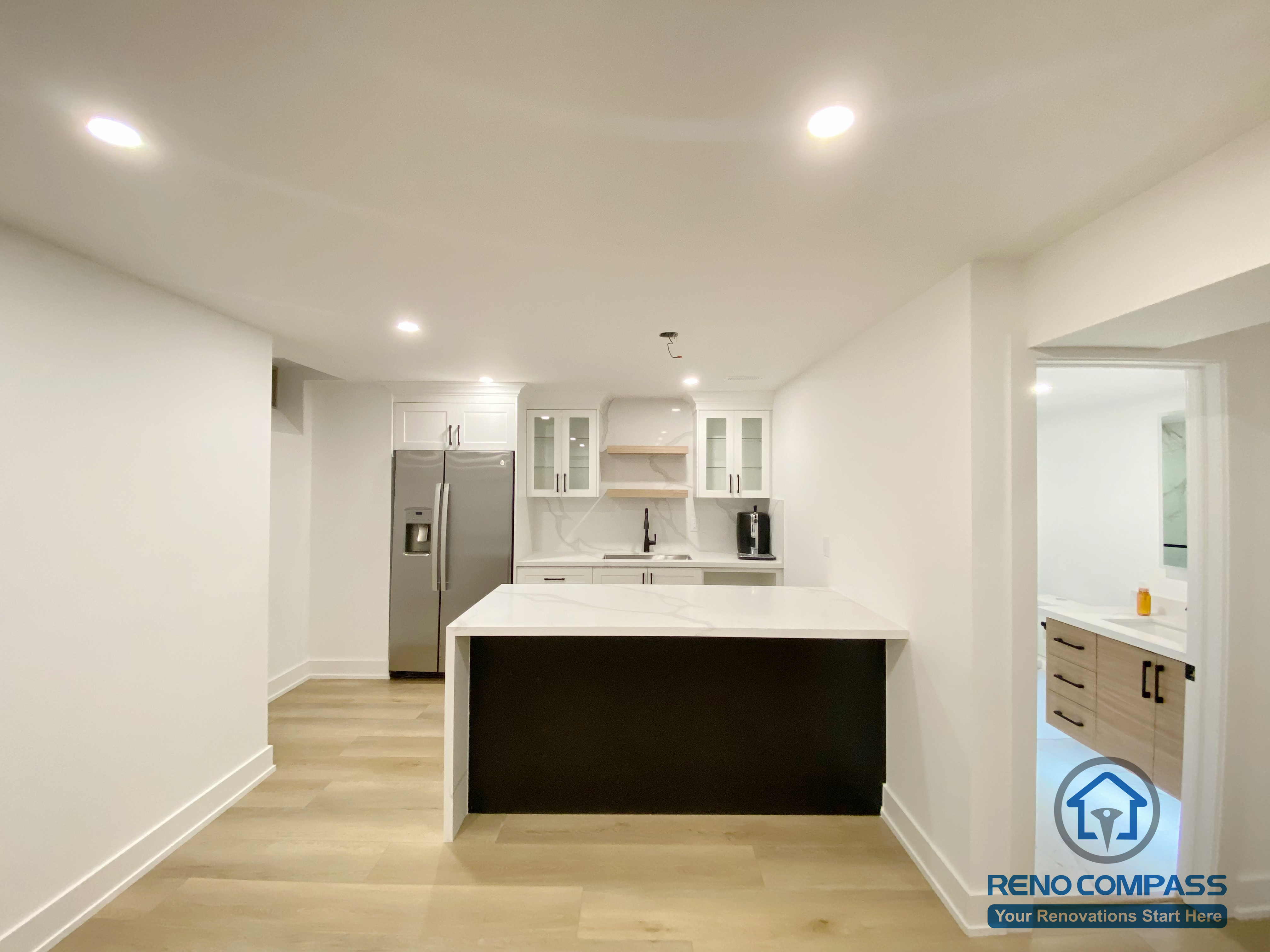This modern basement kitchen includes a functional island layout, clean cabinetry, and efficient lighting. Designed to support entertaining and everyday use, the space seamlessly connects with the surrounding basement living areas.