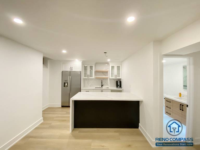 This modern basement kitchen includes a functional island layout, clean cabinetry, and efficient lighting. Designed to support entertaining and everyday use, the space seamlessly connects with the surrounding basement living areas.
