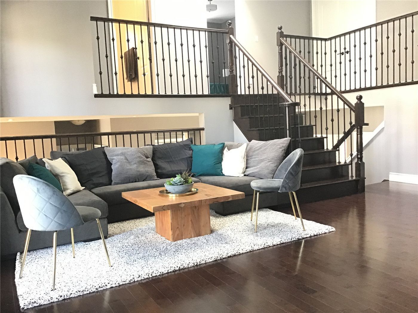 This Markham full home renovation features a spacious open-concept living area with modern staircase design, dark hardwood flooring, and a comfortable seating layout. The elevated ceiling and railing details create visual depth, while the open flow enhances connectivity between levels. Completed by a trusted Toronto Renovation Company, this design blends functionality with contemporary style.