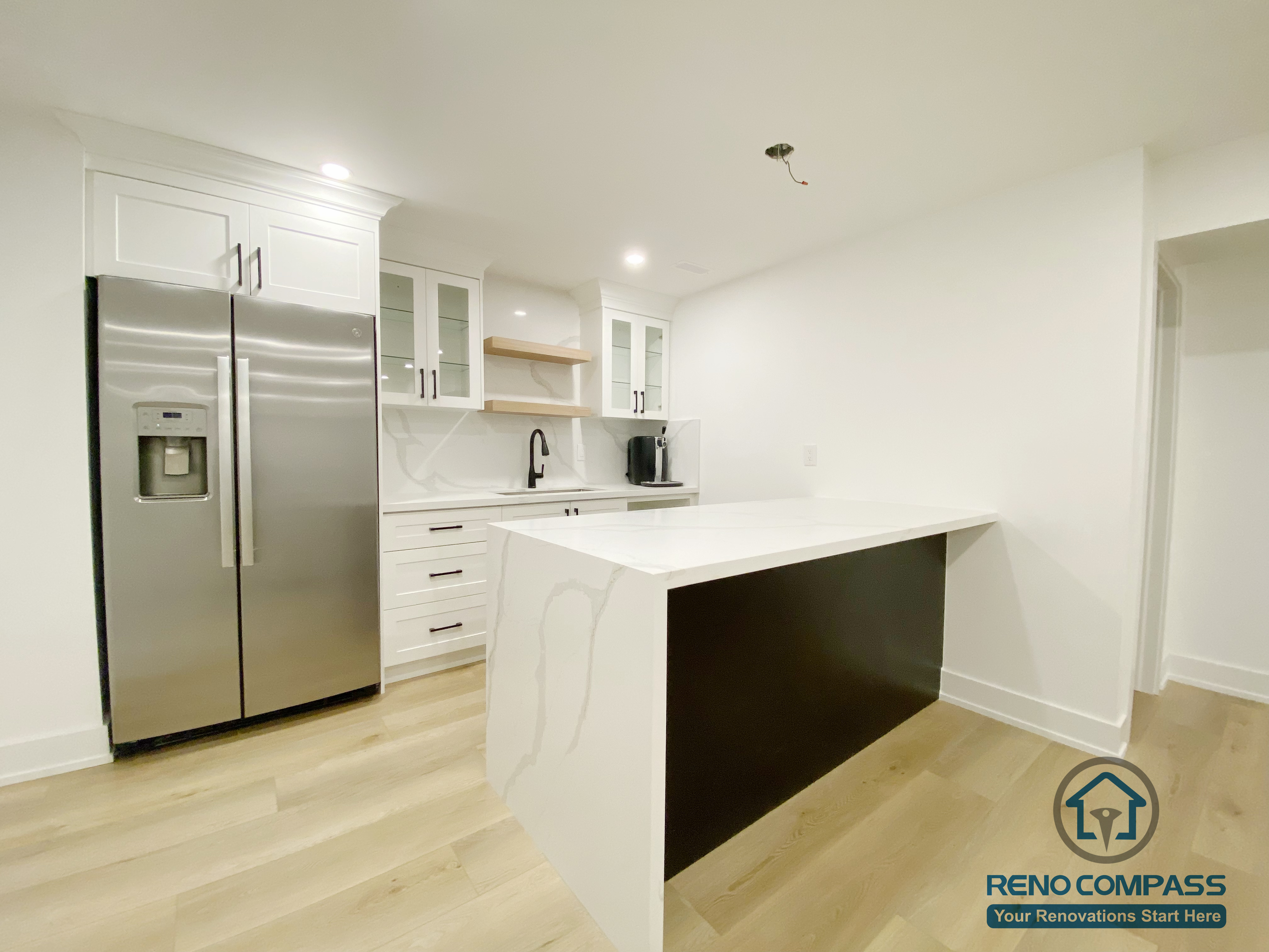 This modern basement kitchen includes a functional island layout, clean cabinetry, and efficient lighting. Designed to support entertaining and everyday use, the space seamlessly connects with the surrounding basement living areas.