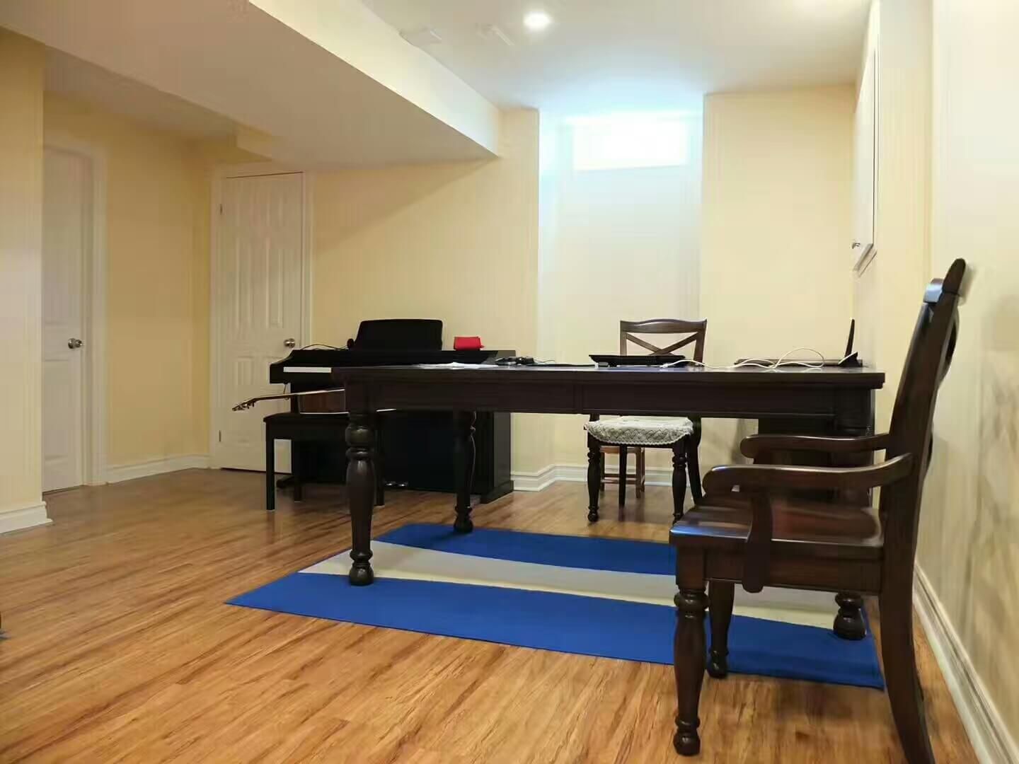 A bright and spacious basement office setup in a Vaughan renovation project, featuring wood‑look flooring, soft neutral walls, recessed lighting, and a large traditional desk with seating. A functional multi‑purpose area ideal for work, studying, or hobbies.