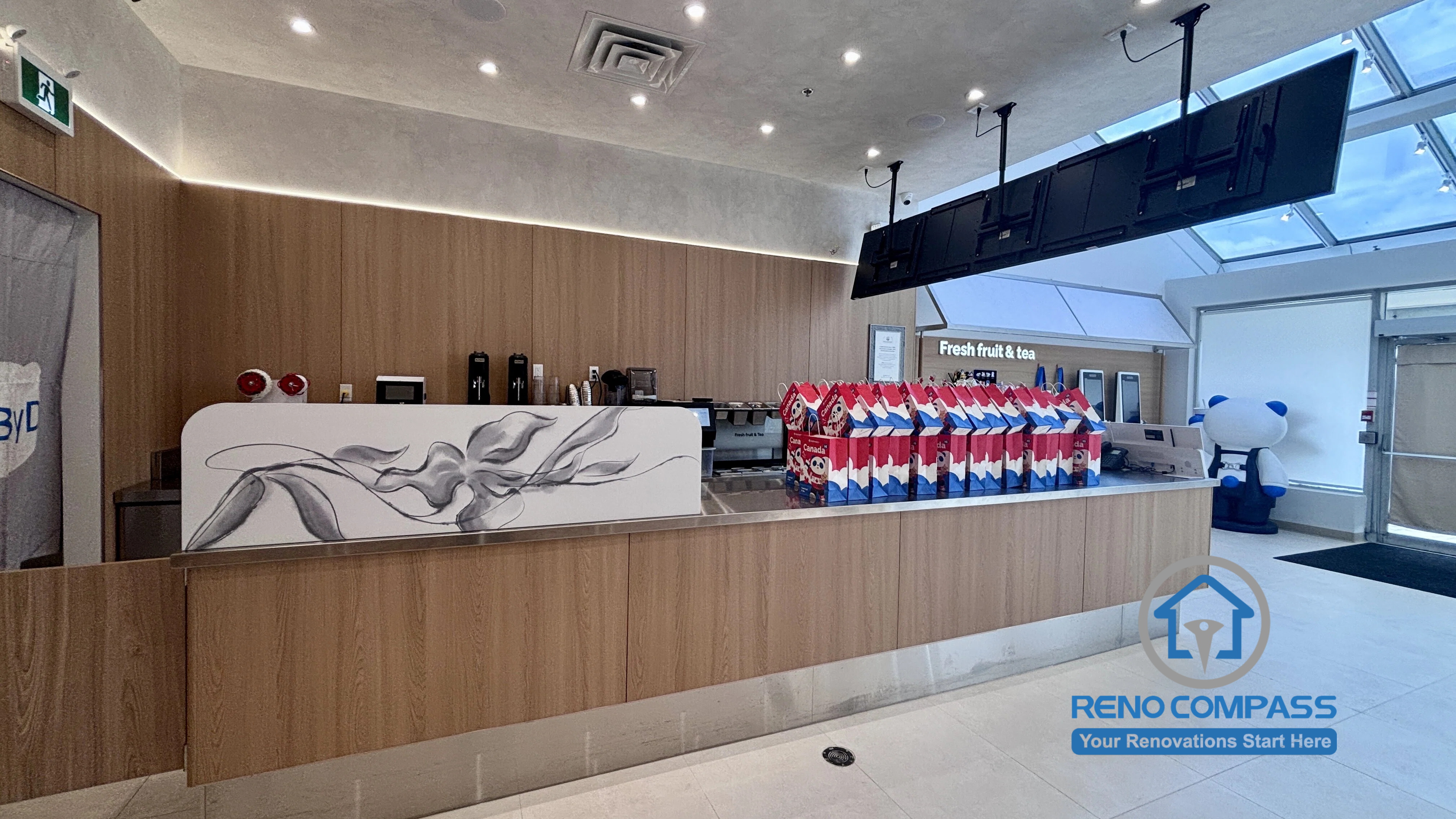 Completed TEABYDO bubble tea shop renovation in Richmond Hill featuring a custom front service counter, modern wood-tone commercial millwork, integrated LED lighting, digital menu display system, skylight ceiling, and clean minimalist café interior design. This commercial renovation project was completed by Reno Compass serving Richmond Hill, Toronto, and the GTA.