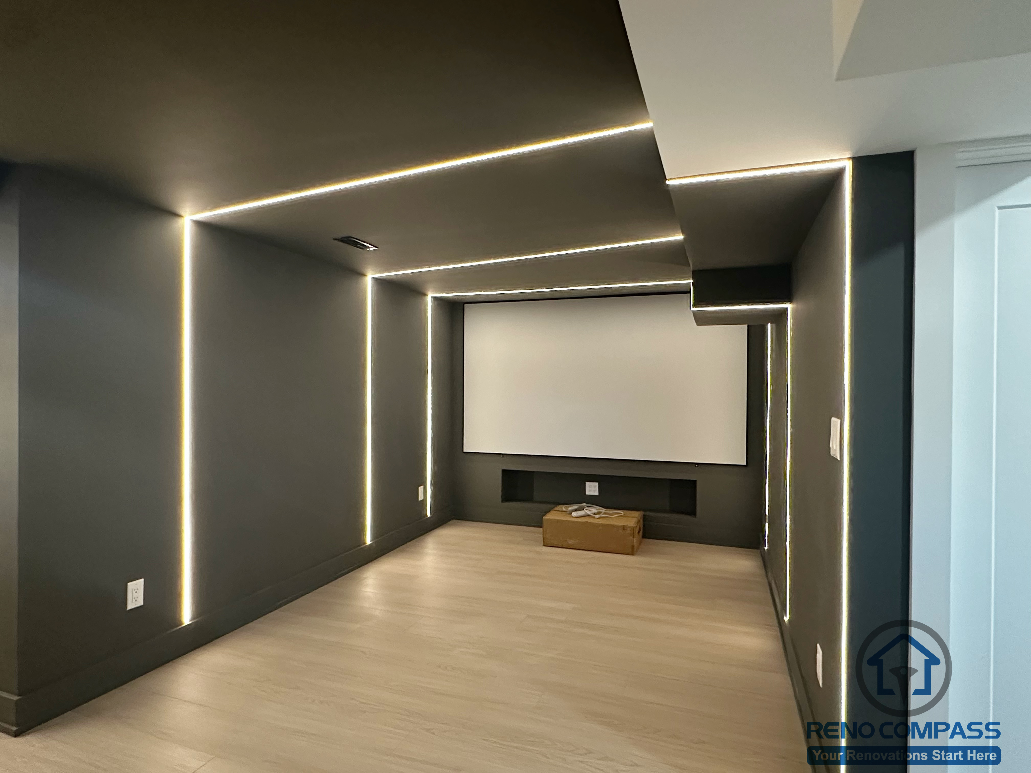 This Markham interior renovation features a custom-designed home theater space focused on immersive viewing and clean architectural lines. Integrated linear LED lighting is built into the walls and ceiling to create a controlled, cinematic atmosphere while enhancing spatial depth. Dark matte finishes reduce visual distraction, allowing the screen to remain the focal point of the room. The layout prioritizes acoustics, lighting balance, and comfort, resulting in a dedicated media room that feels modern, minimal, and purpose-built.