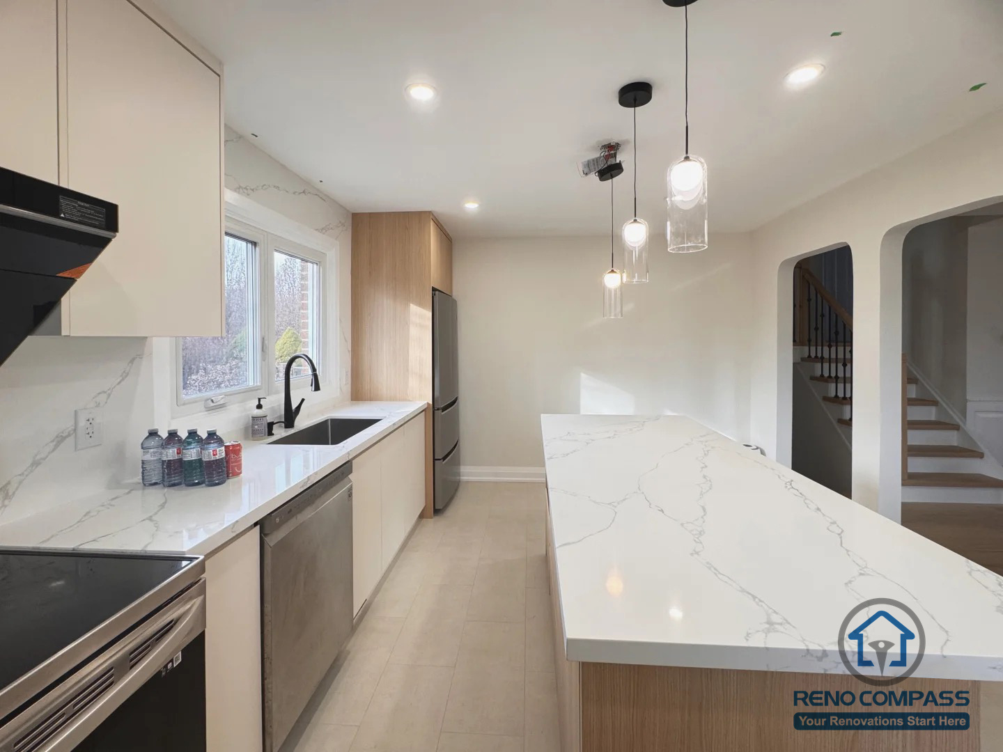 This Oakville kitchen renovation features a clean, modern island layout designed to improve workflow, storage, and natural light. The space was reconfigured with custom cabinetry, quartz countertops, and integrated pendant lighting to create a bright, functional kitchen that connects seamlessly with the surrounding living areas. Neutral tones and warm wood accents bring balance between modern aesthetics and everyday comfort.