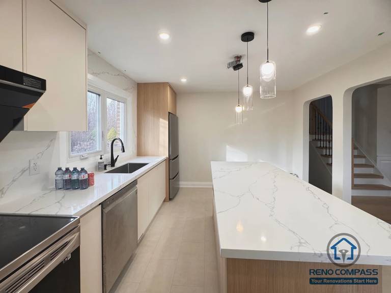 This Oakville kitchen renovation features a clean, modern island layout designed to improve workflow, storage, and natural light. The space was reconfigured with custom cabinetry, quartz countertops, and integrated pendant lighting to create a bright, functional kitchen that connects seamlessly with the surrounding living areas. Neutral tones and warm wood accents bring balance between modern aesthetics and everyday comfort.