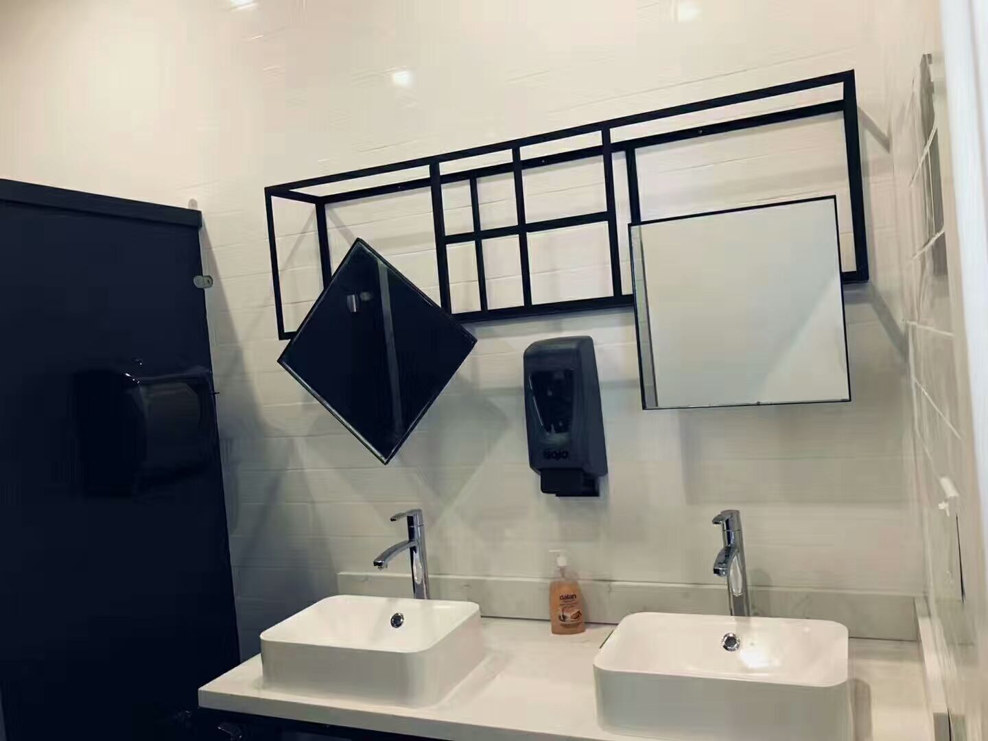 This image showcases a modern commercial washroom completed as part of a cafeteria renovation project in North York. The space features dual vessel sinks, wall-mounted faucets, framed mirrors, and a clean tiled wall finish designed for durability and easy maintenance. The layout supports high-traffic commercial use while maintaining a sleek and professional appearance. This North York cafeteria commercial renovation reflects practical washroom planning, quality fixture installation, and attention to hygiene standards by a Toronto renovation company specializing in commercial interior renovations.