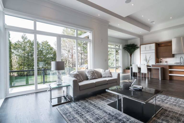 This expansive open-concept living and kitchen space is part of a 4,500 sq ft luxury home renovation in Toronto. Floor-to-ceiling windows flood the interior with natural light, enhancing the modern layout and seamless connection between living, dining, and kitchen areas. Dark hardwood flooring, clean architectural lines, and contemporary finishes create a refined yet welcoming atmosphere. Designed and built by a trusted Toronto Renovation Company, Reno Compass Inc., this project showcases premium craftsmanship and sophisticated residential living.