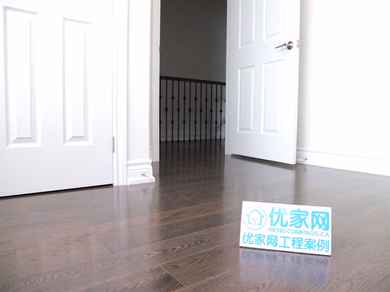 Interior hallway view from a Scarborough home addition project featuring newly installed dark hardwood flooring, clean white doors, and modern trim finishes. The renovation improves interior flow and creates a bright, polished living space within the expanded home layout.