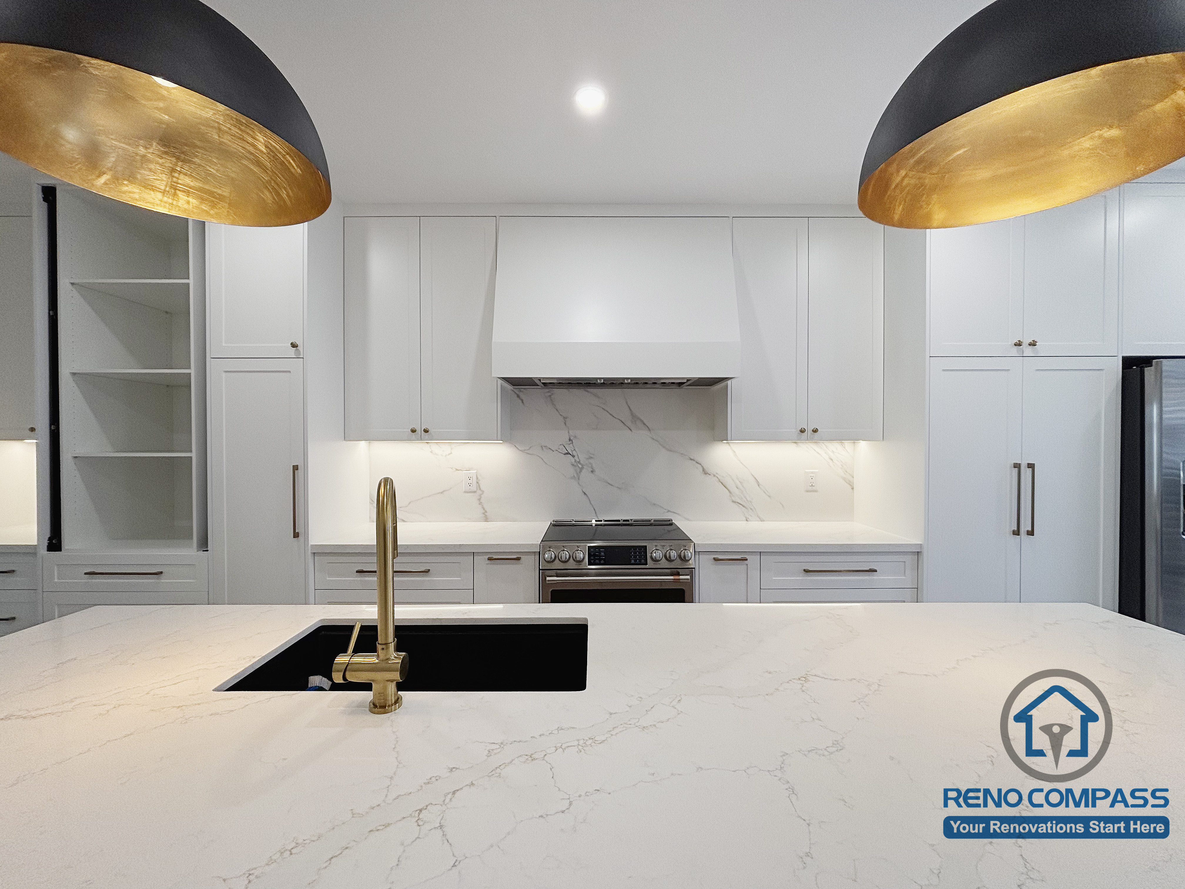 This Oakville kitchen renovation showcases a symmetrical layout centered on the main cooking zone, framed by full-height cabinetry and a streamlined hood design. The island sits in the foreground with an integrated sink, reinforcing a clear visual axis between preparation and cooking areas. Consistent materials, balanced proportions, and controlled lighting contribute to a calm and cohesive kitchen environment. Completed by Reno Compass, this design reflects precision, restraint, and long-term functionality in a modern Oakville kitchen renovation.