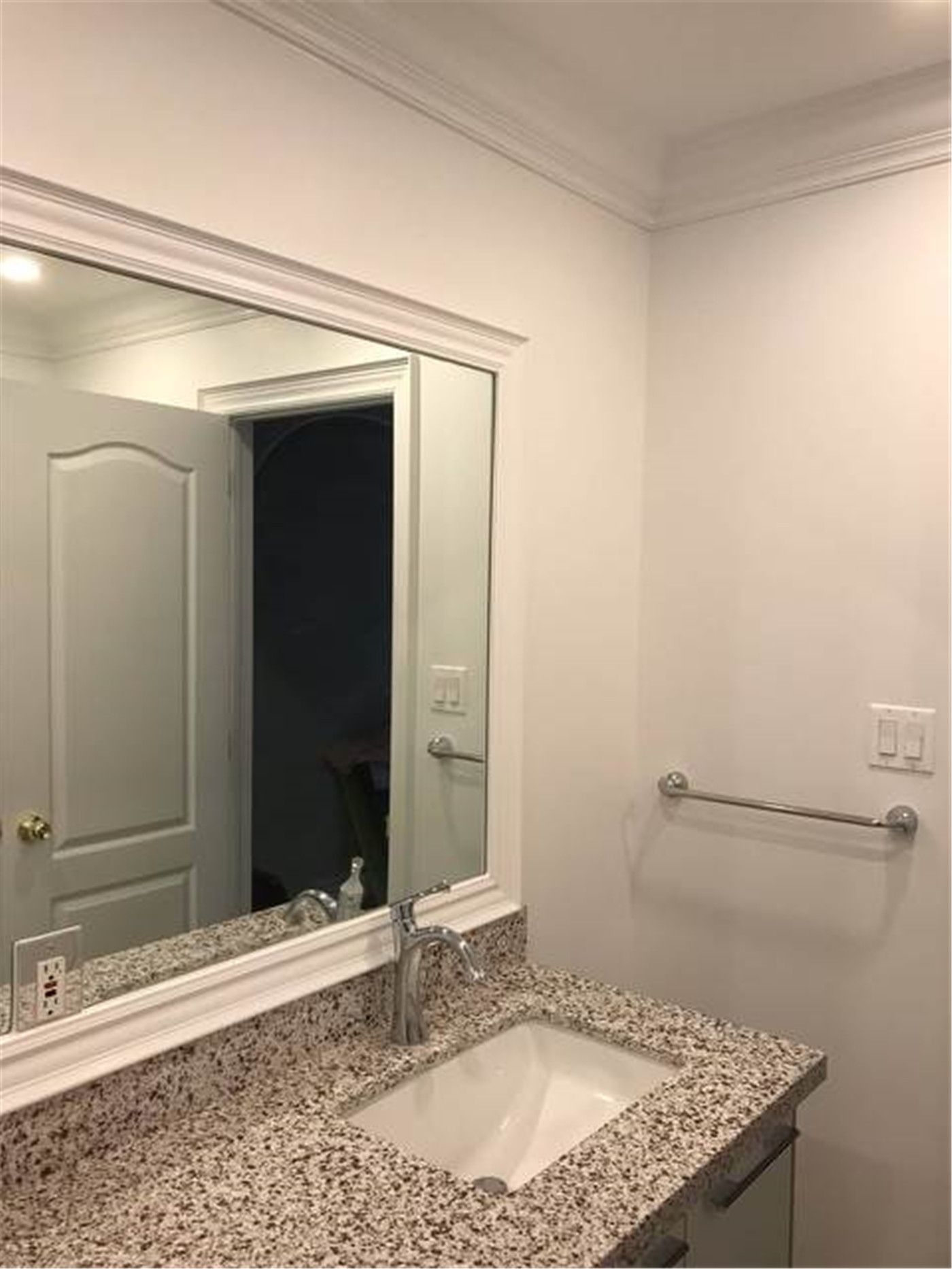 This North York bathroom renovation features a granite vanity countertop with an undermount sink, framed wall mirror, and clean, neutral finishes. The simple layout emphasizes durability, easy maintenance, and everyday functionality, making it well suited for family or guest bathroom use.