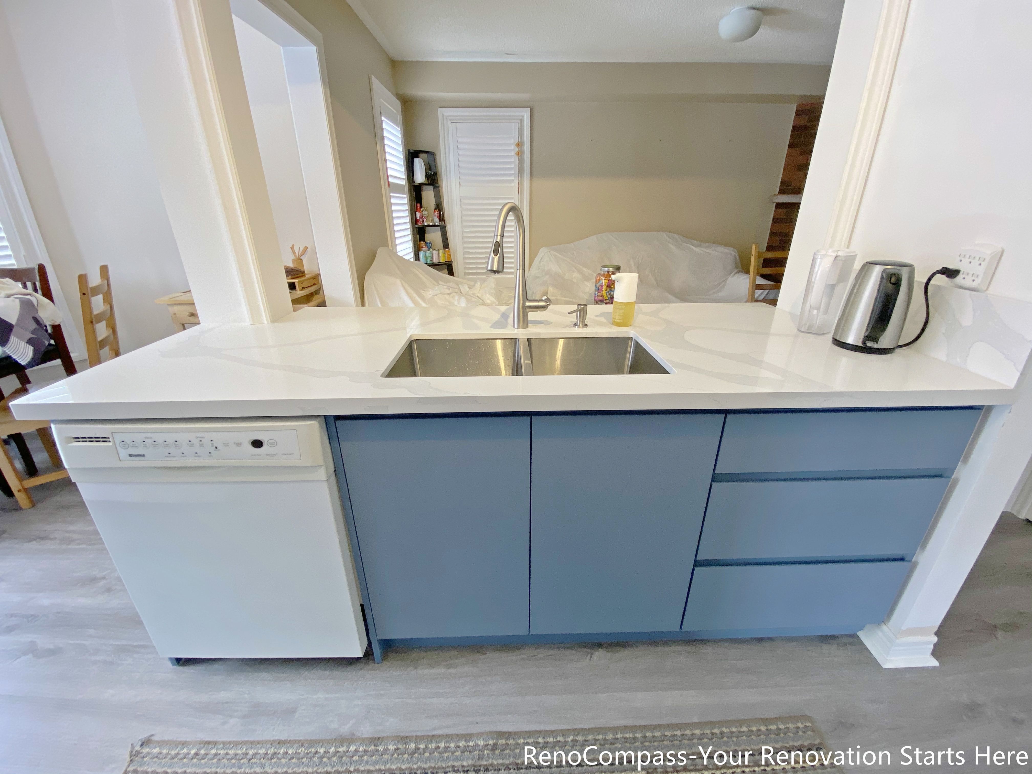 This image features a functional kitchen island completed as part of a Mississauga kitchen renovation. The island is topped with a durable quartz countertop and includes an undermount sink, modern faucet, and an integrated dishwasher for efficient cleanup. Base cabinetry provides concealed storage while maintaining a clean and streamlined appearance. Positioned to connect the kitchen with the surrounding living space, this island design supports everyday meal preparation, cleaning, and casual use in modern Mississauga homes.