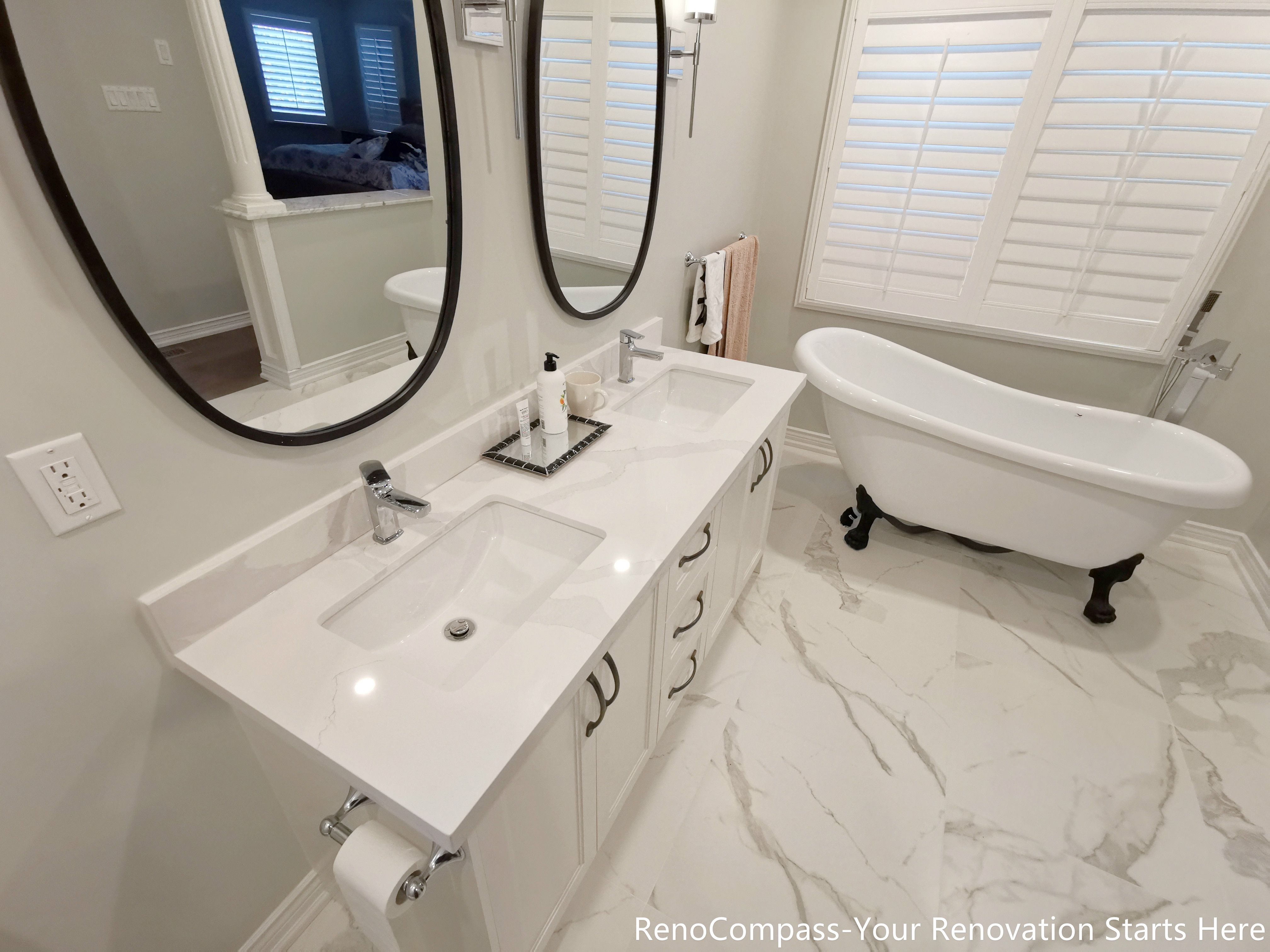 he bathroom renovation features elegant marble flooring, which adds visual depth while enhancing durability and ease of maintenance. A custom double vanity provides ample storage and shared functionality, making the space ideal for daily routines without congestion. An independent freestanding bathtub serves as a focal point of the room, offering a spa-inspired experience while maintaining a clean, balanced layout.