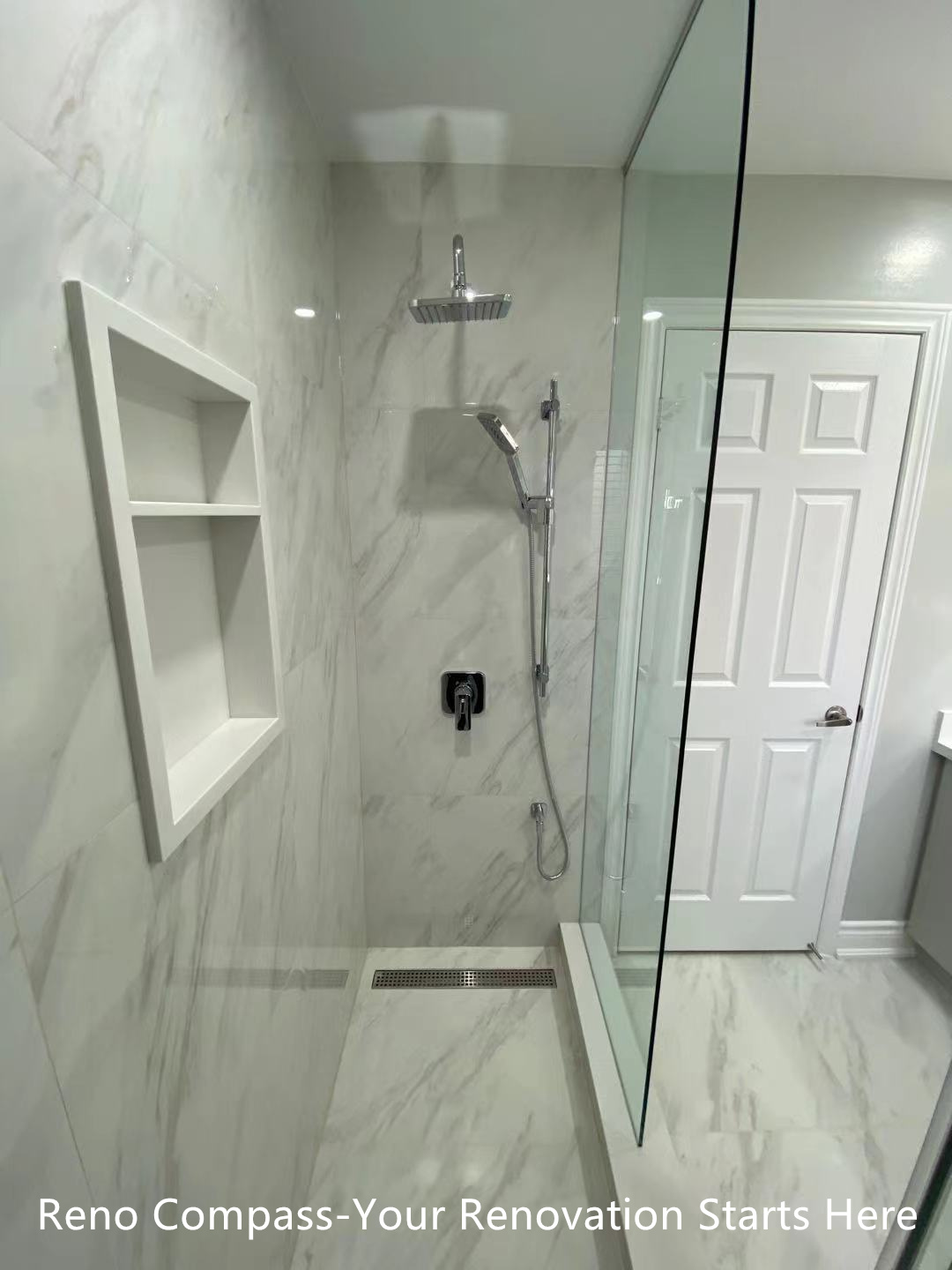 This Oakville interior renovation features a modern walk-in shower designed with frameless glass panels and full-height marble-look porcelain tiles. The clean glass enclosure enhances visual openness while allowing natural and artificial light to flow through the space. A rain shower system, wall-mounted hand shower, and built-in niche provide both comfort and functionality. The minimalist layout and neutral stone tones create a calm, spa-inspired bathroom environment that is durable, easy to maintain, and ideal for long-term residential use. This project reflects the precision detailing and modern design standards expected from a professional Toronto renovation company.