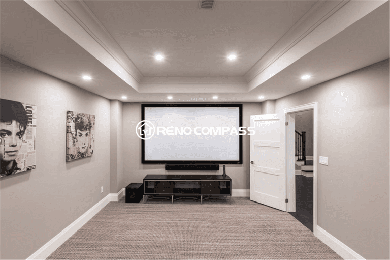 Modern luxury basement renovation in Toronto featuring a custom home theater area, recessed lighting, tray ceiling design, and premium carpeting. This professionally finished basement creates a comfortable entertainment space with elegant neutral tones and high-end detailing, completed by a trusted Toronto renovation company, Reno Compass Inc.