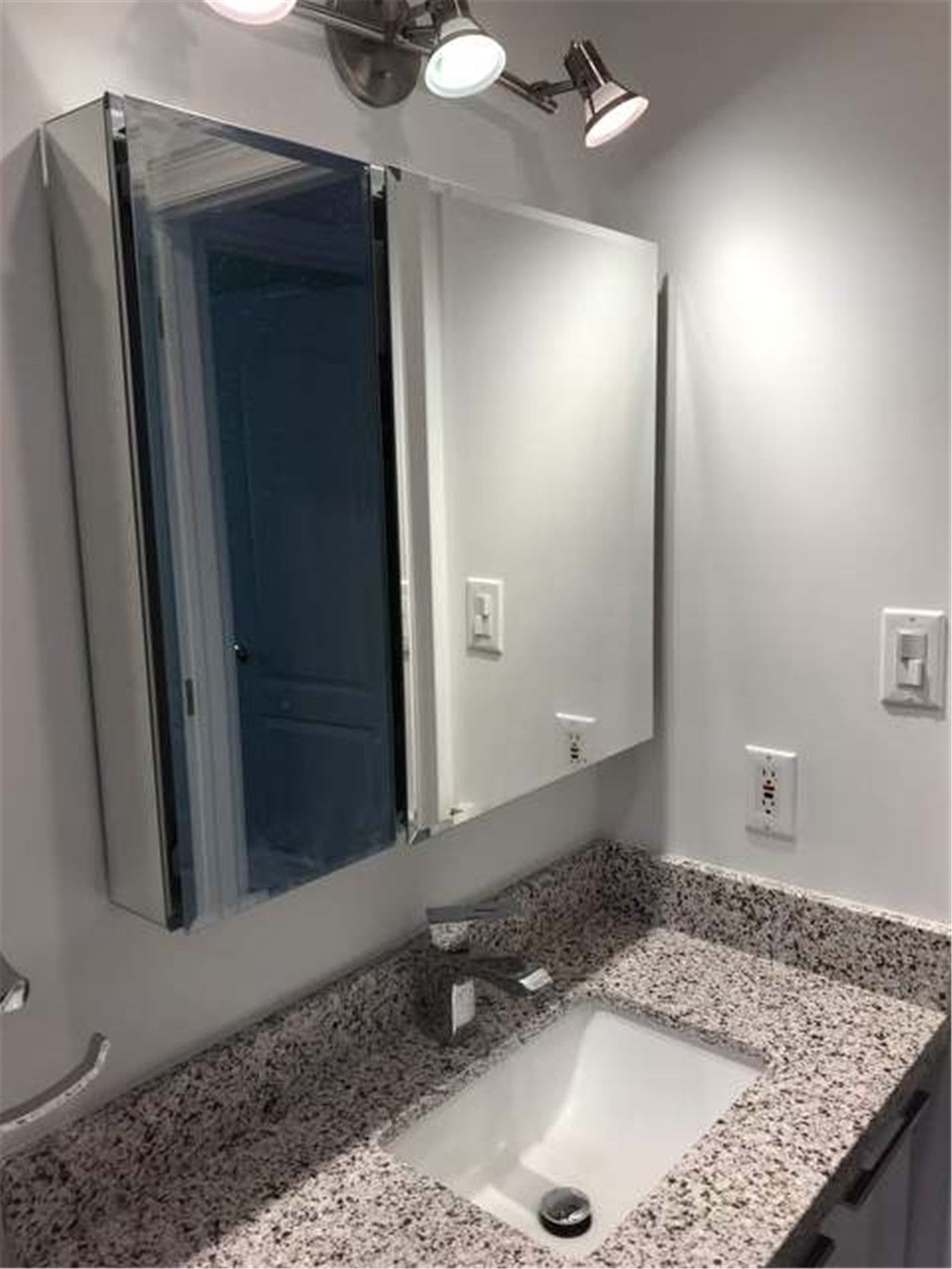 This North York bathroom renovation showcases a custom vanity with a durable granite countertop and undermount sink, designed for both functionality and clean aesthetics. The wall-mounted mirror cabinet provides additional storage while maintaining a streamlined look. Modern lighting fixtures enhance brightness and visibility, creating a comfortable and practical daily-use space. Completed by Reno Compass Inc., this bathroom upgrade combines efficient layout planning with long-lasting materials suitable for modern family living.