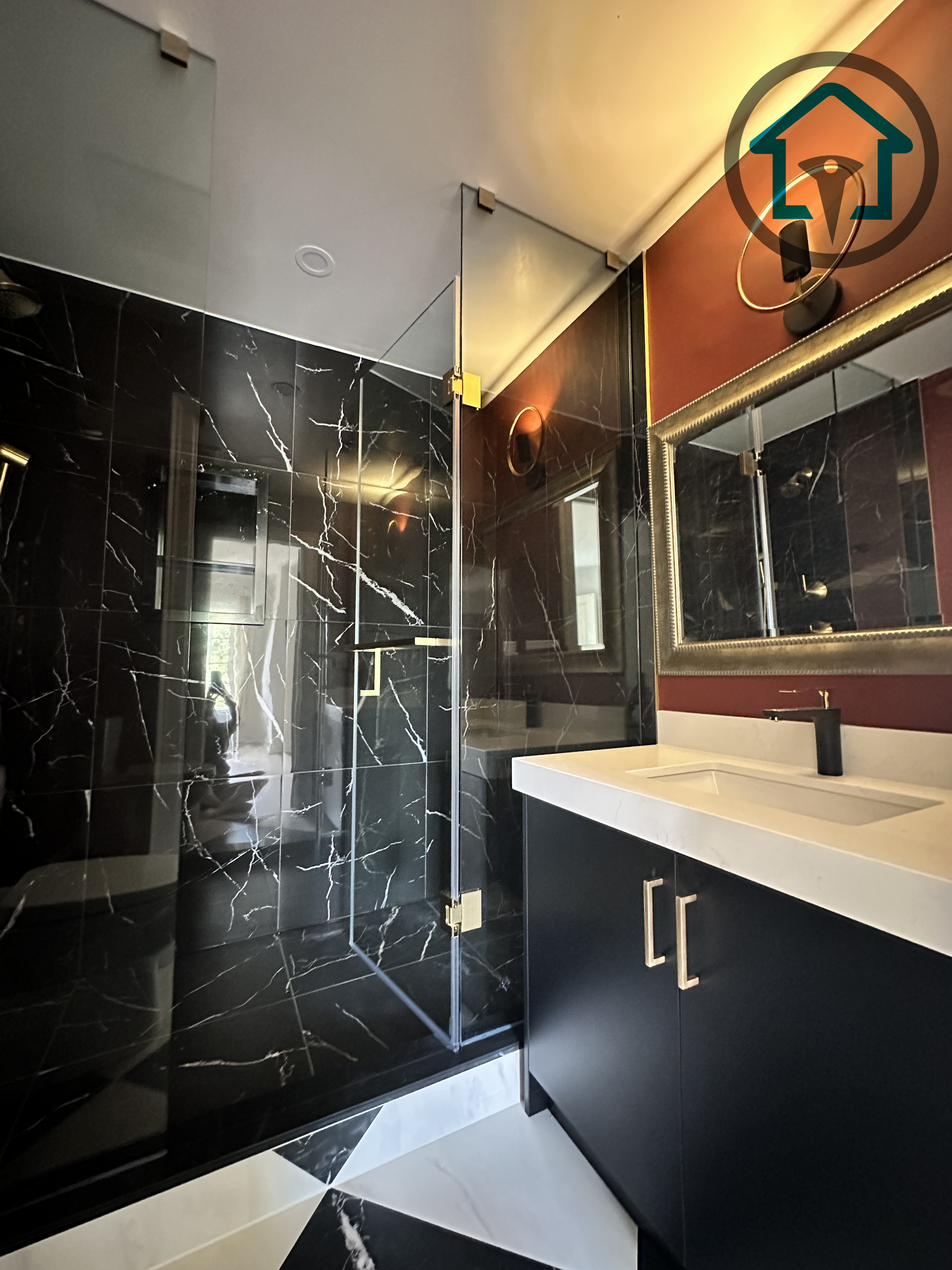 This powder room renovation showcases a dramatic black marble walk-in shower paired with a minimalist vanity and clean-lined fixtures. Frameless glass panels enhance openness while bold material contrast adds visual depth. Completed as part of a North York interior renovation, this space reflects the craftsmanship and design coordination of an experienced Toronto renovation company.